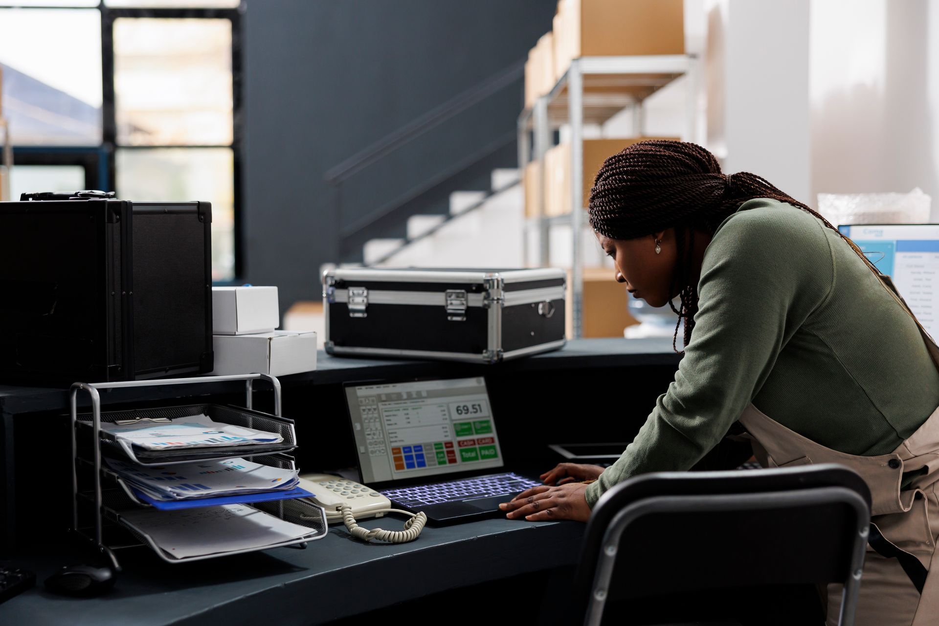 a woman is standing at a desk in front of a laptop computer | Apple Business Security