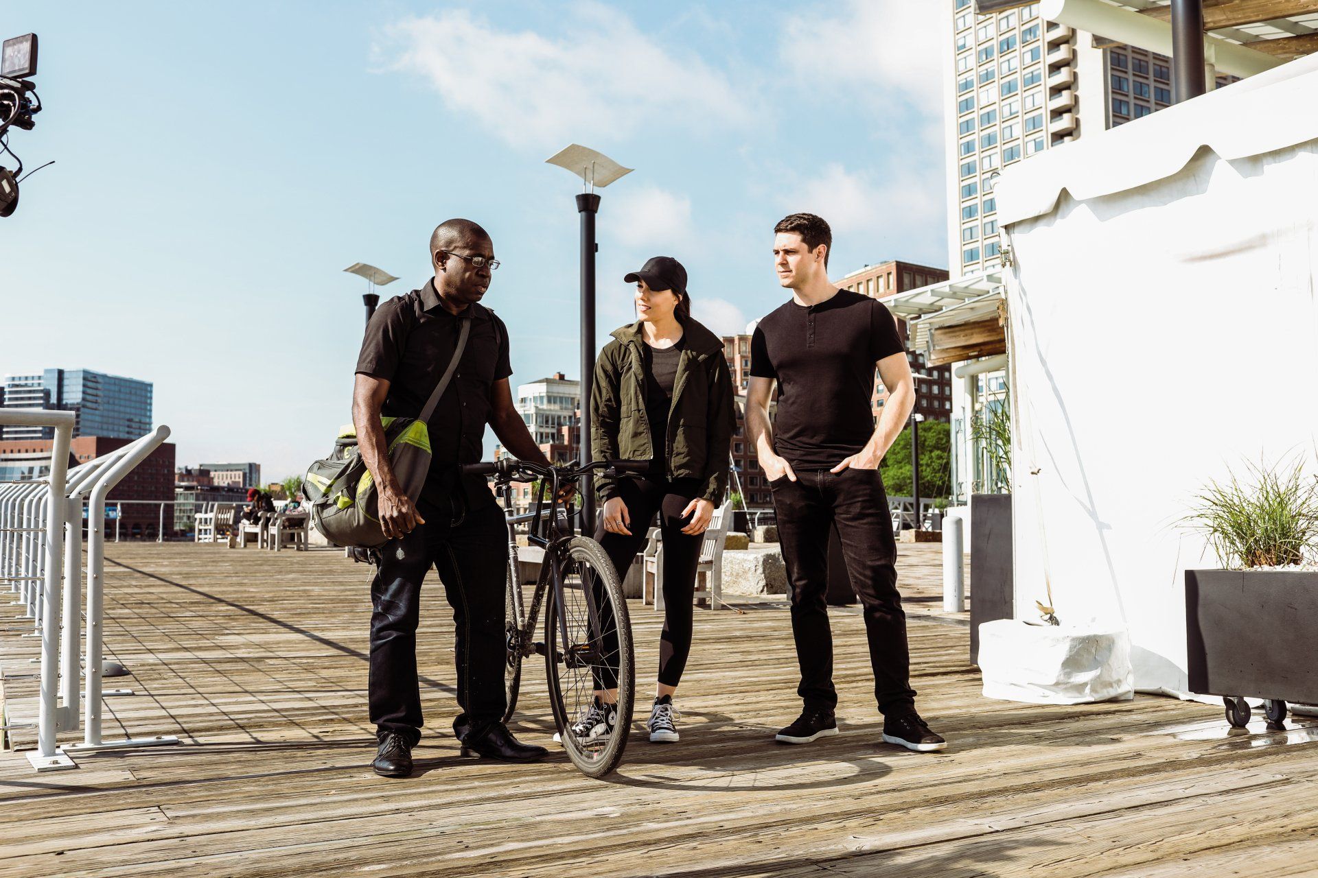 Brandon T. Adams, David France, and Samantha Rossin walking and filming on boardwalk