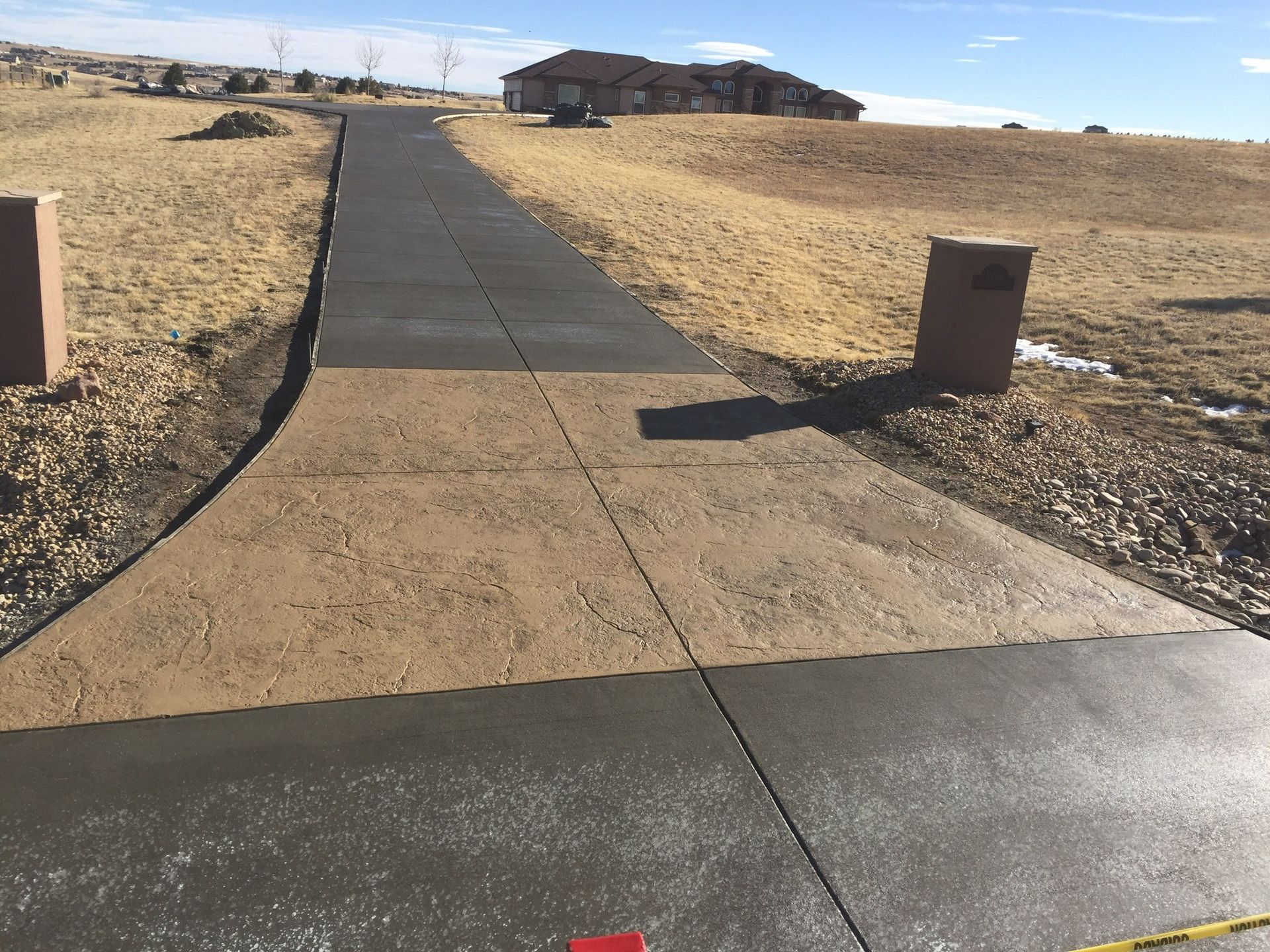 Workers smoothing wet concrete for a driveway.