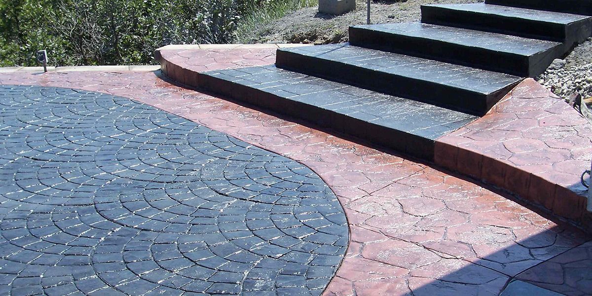 Concrete patio with steps, stamped with geometric patterns and bordered in brick red. Concrete patio with steps, stamped with geometric patterns and bordered in brick red.