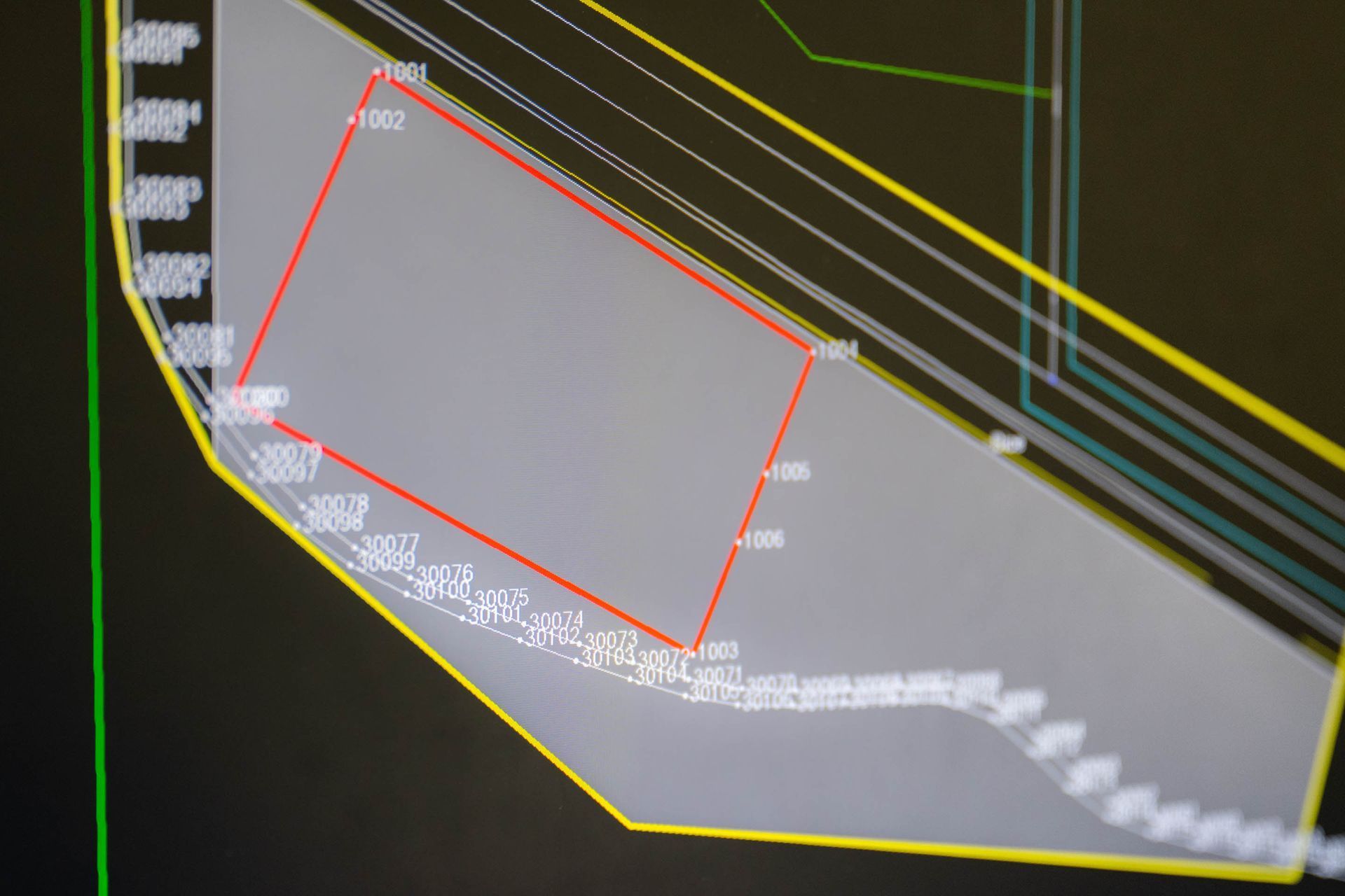Computer screen displaying a gray shape, outlined in yellow, with a red rectangular overlay. White text labels features.