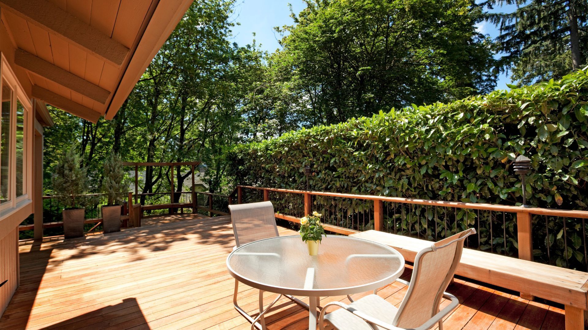 Shaded wooden deck with furniture and lush greenery in Gilbert, AZ, ideal for outdoor relaxation.