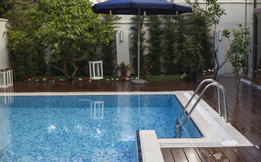 A beautiful photo of a pool deck installed by SanTan Deck Designs. The pool deck surround the luxurious in-ground pool. 