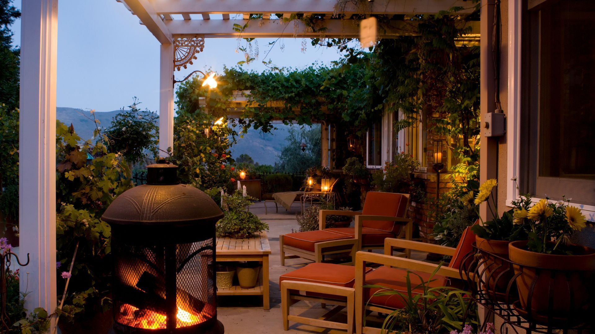 Cozy evening patio in Gilbert, AZ, with warm lighting, cushioned seating, and lush greenery.