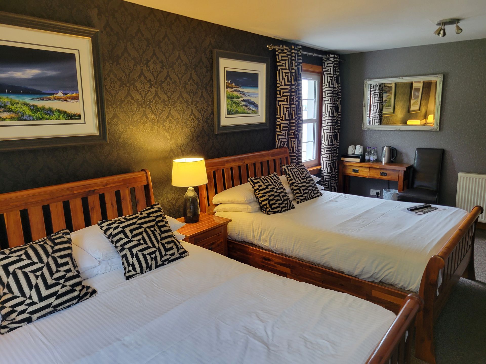 A hotel room with two beds and a television
