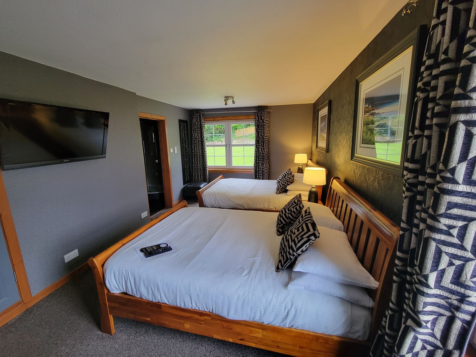A hotel room with two beds and a television