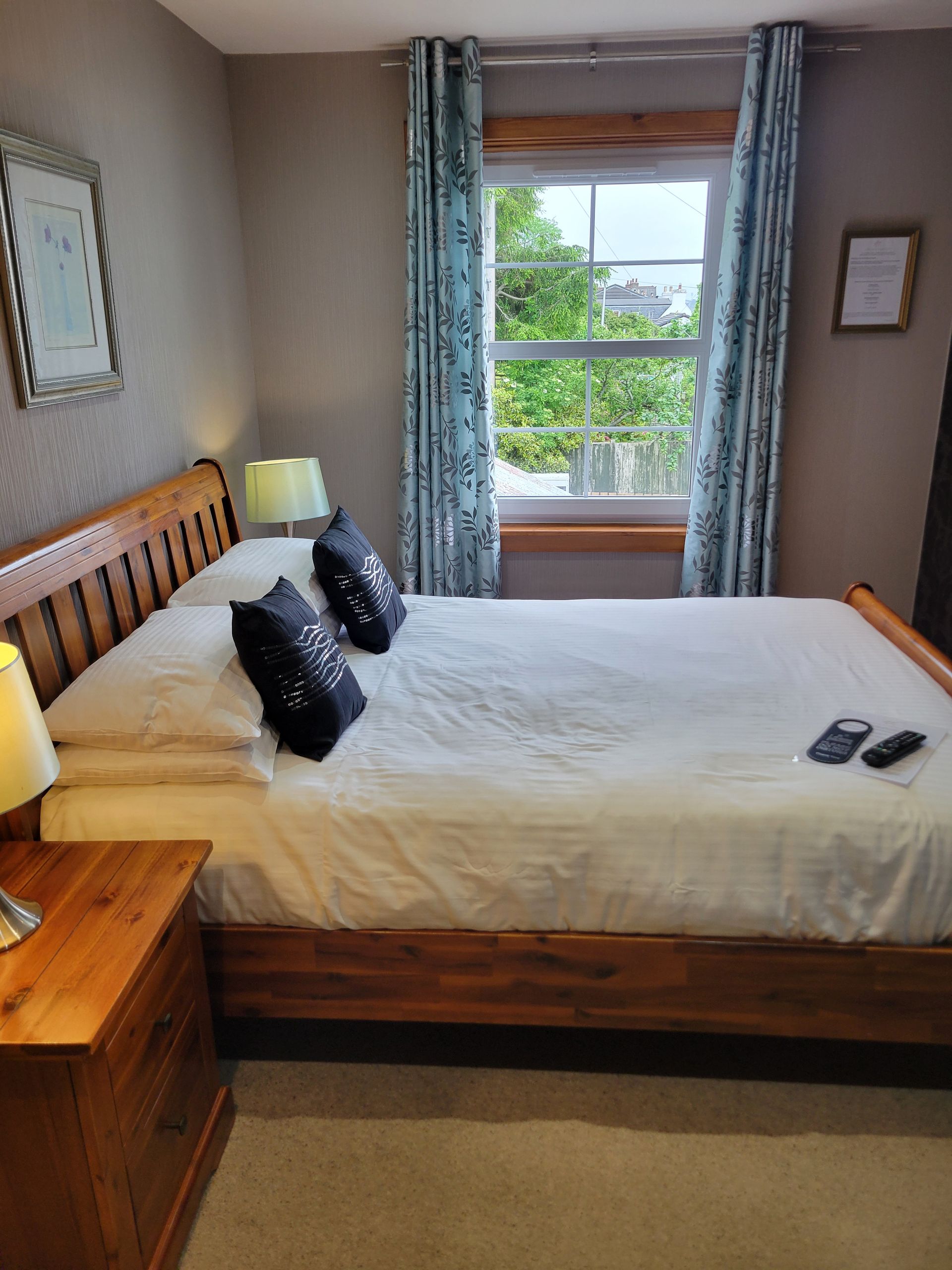 A bedroom with a bed , nightstand , lamp and television.
