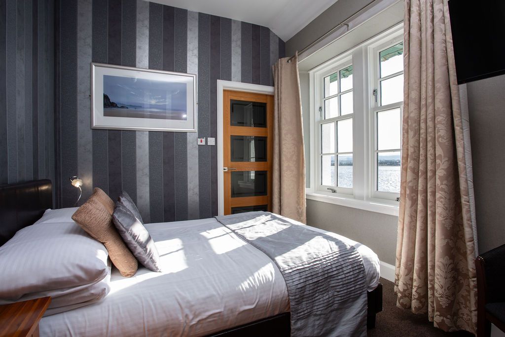 A bedroom with a king size bed and two windows