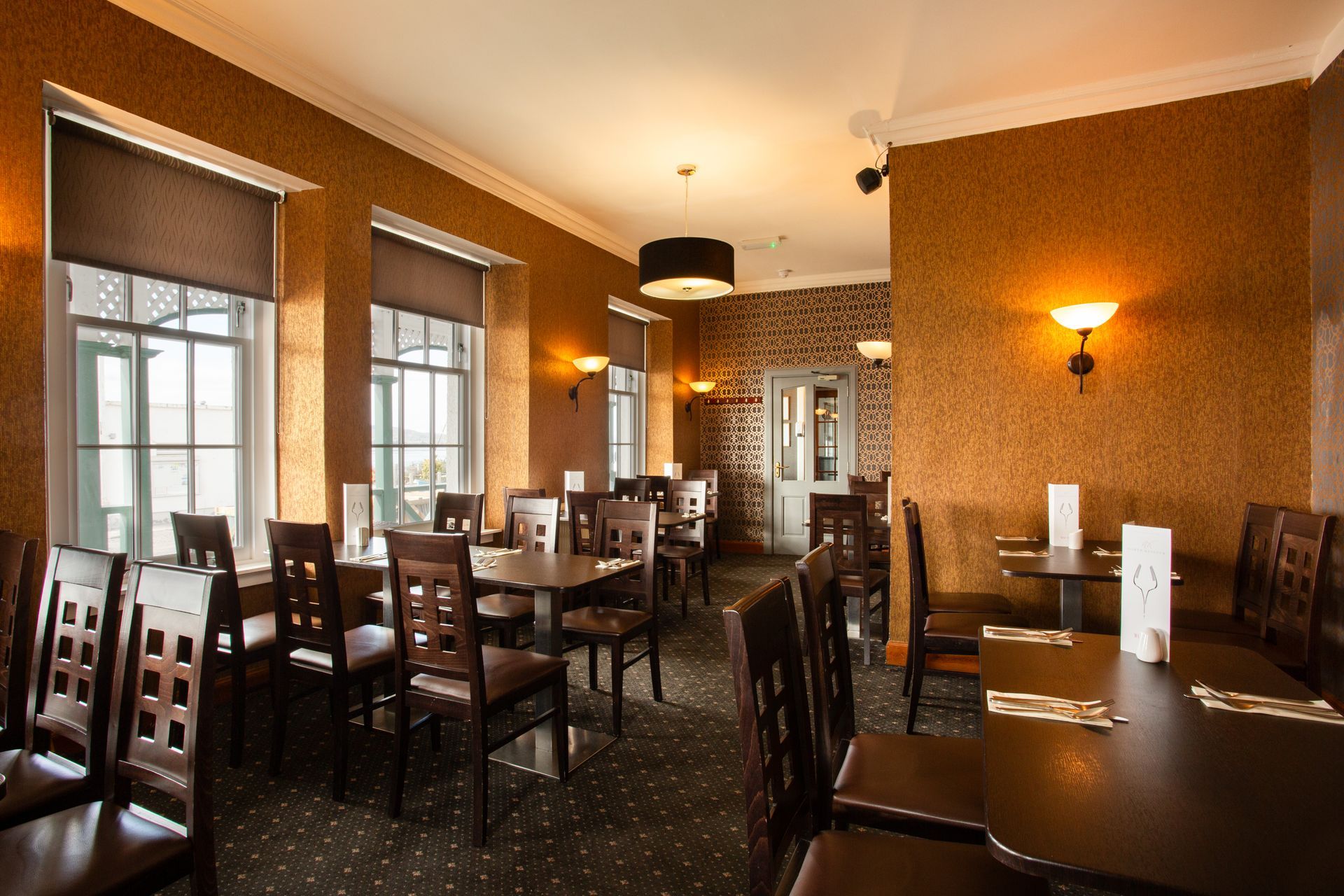 A restaurant with tables and chairs and a large window