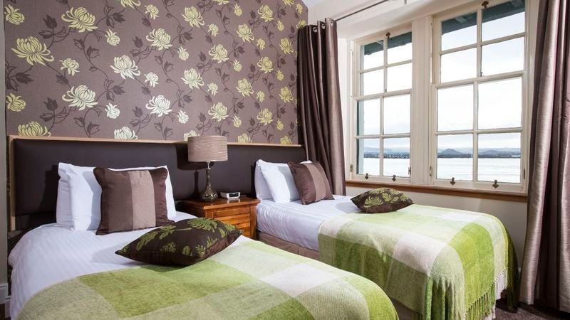 A hotel room with two beds and a window