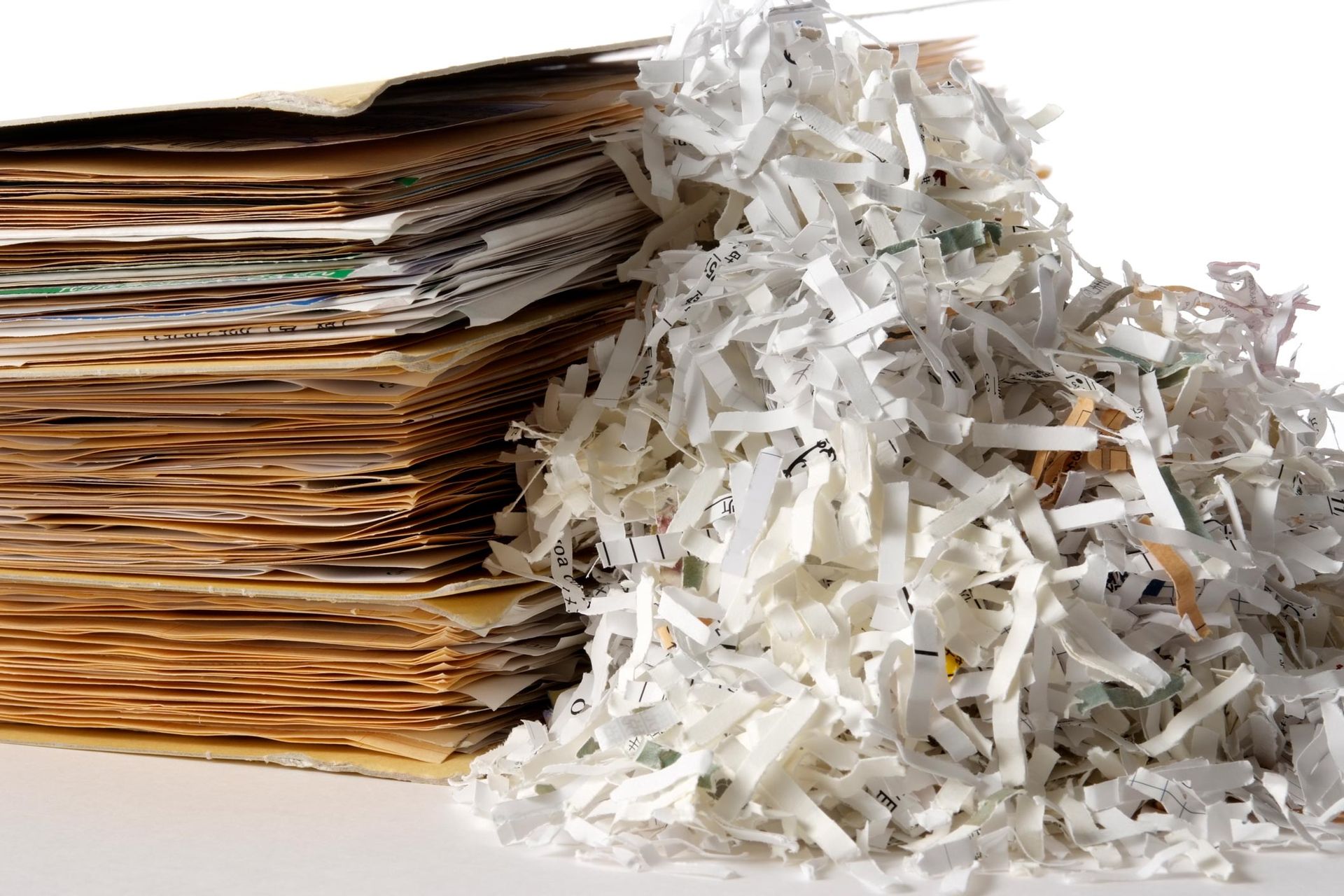 A pile of shredded paper next to a pile of cardboard