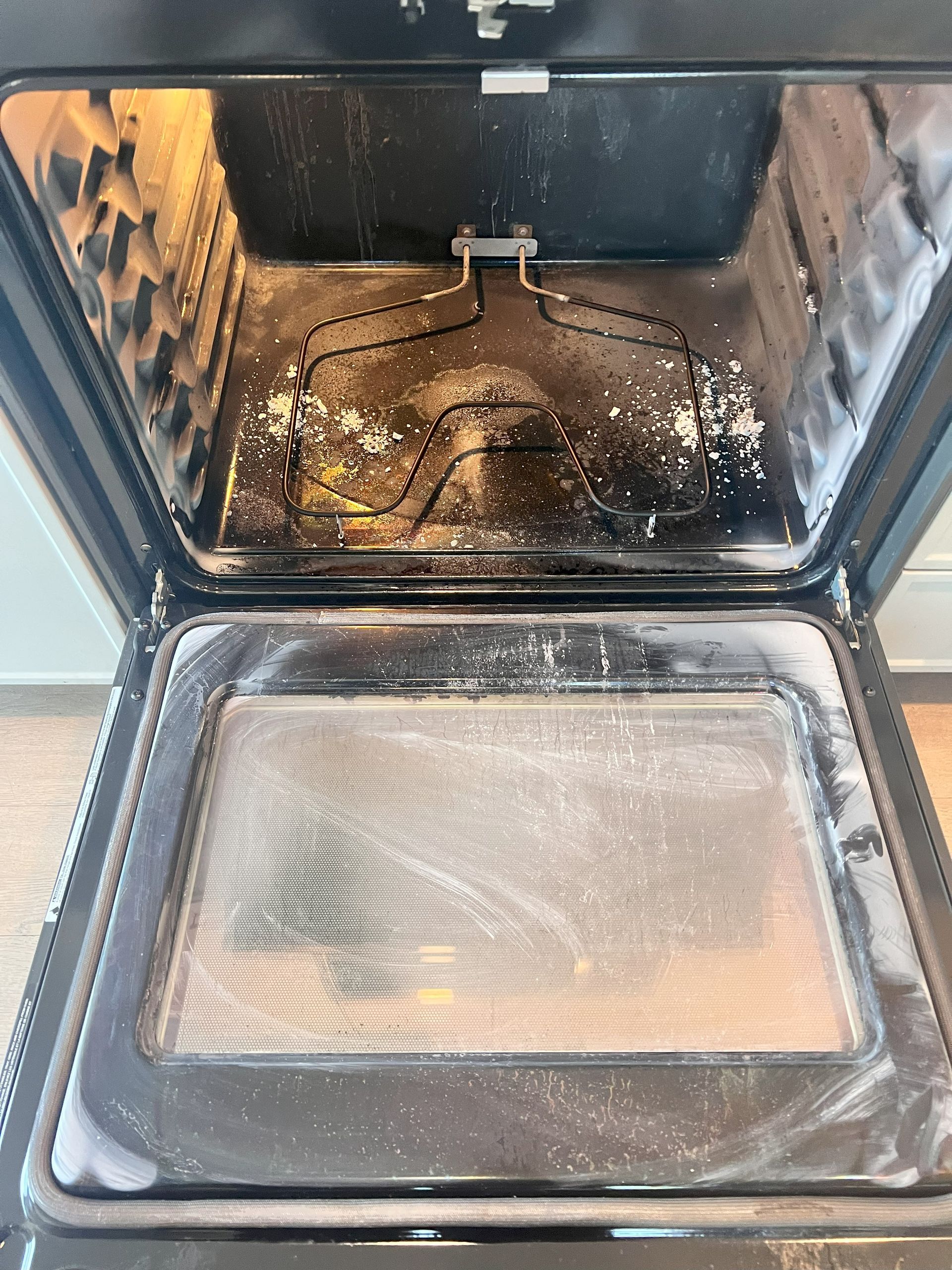 The inside of an oven is very dirty and needs to be cleaned.