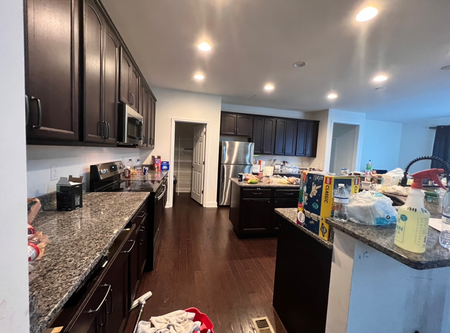A kitchen with a lot of cleaning supplies on the counters.