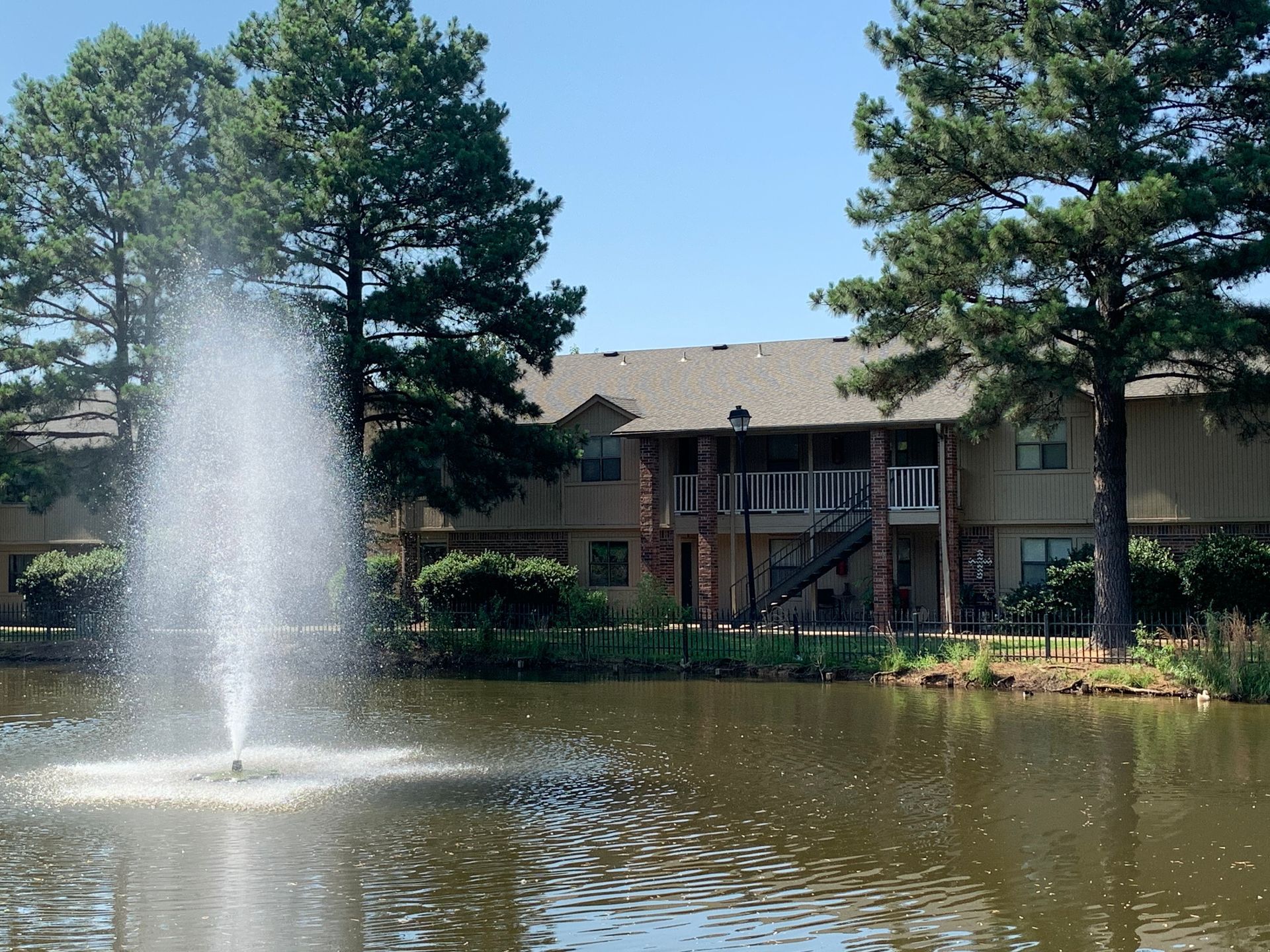 A pond with a fountain in front of a building