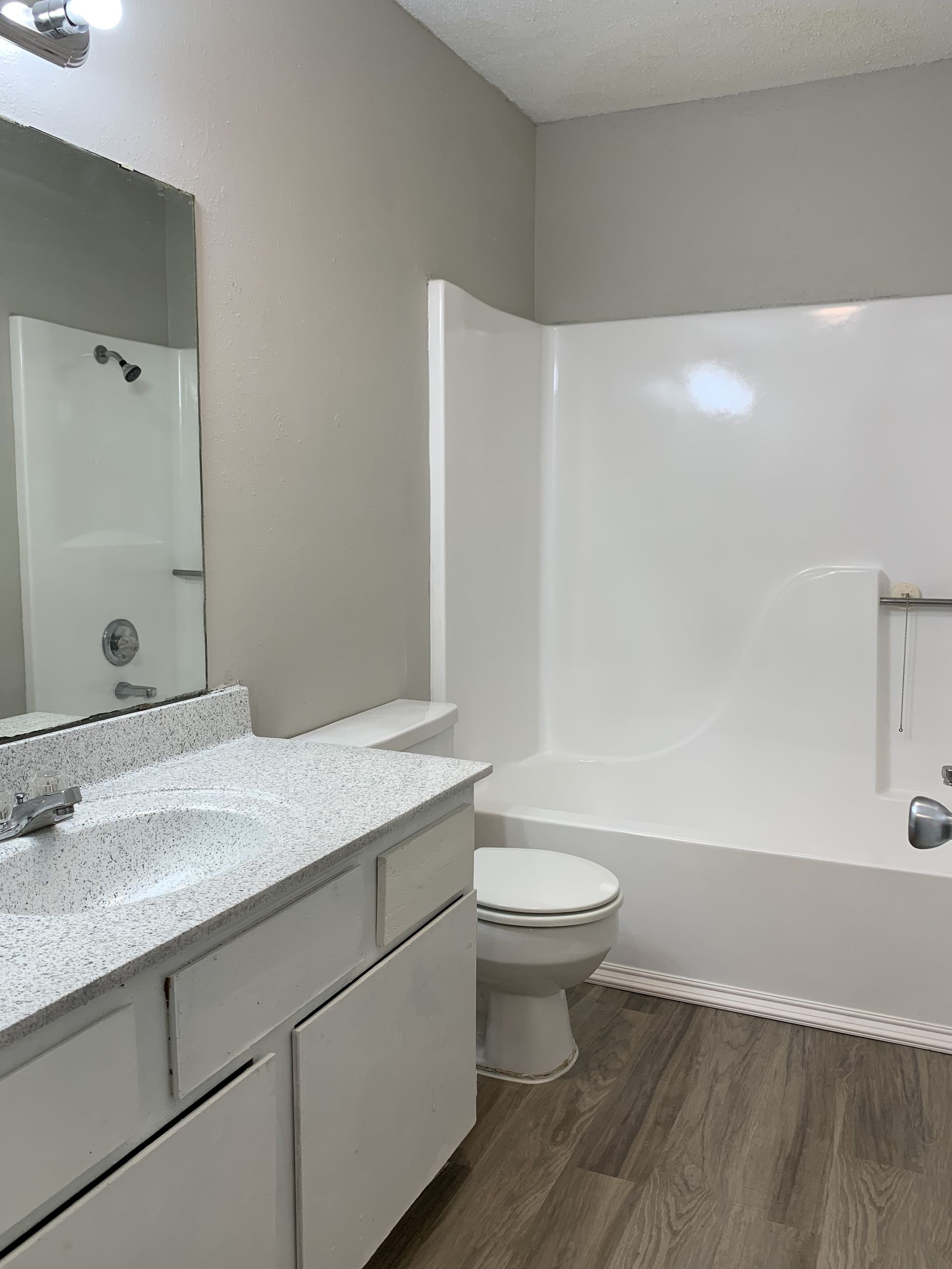 A bathroom with a sink , toilet , bathtub and mirror.