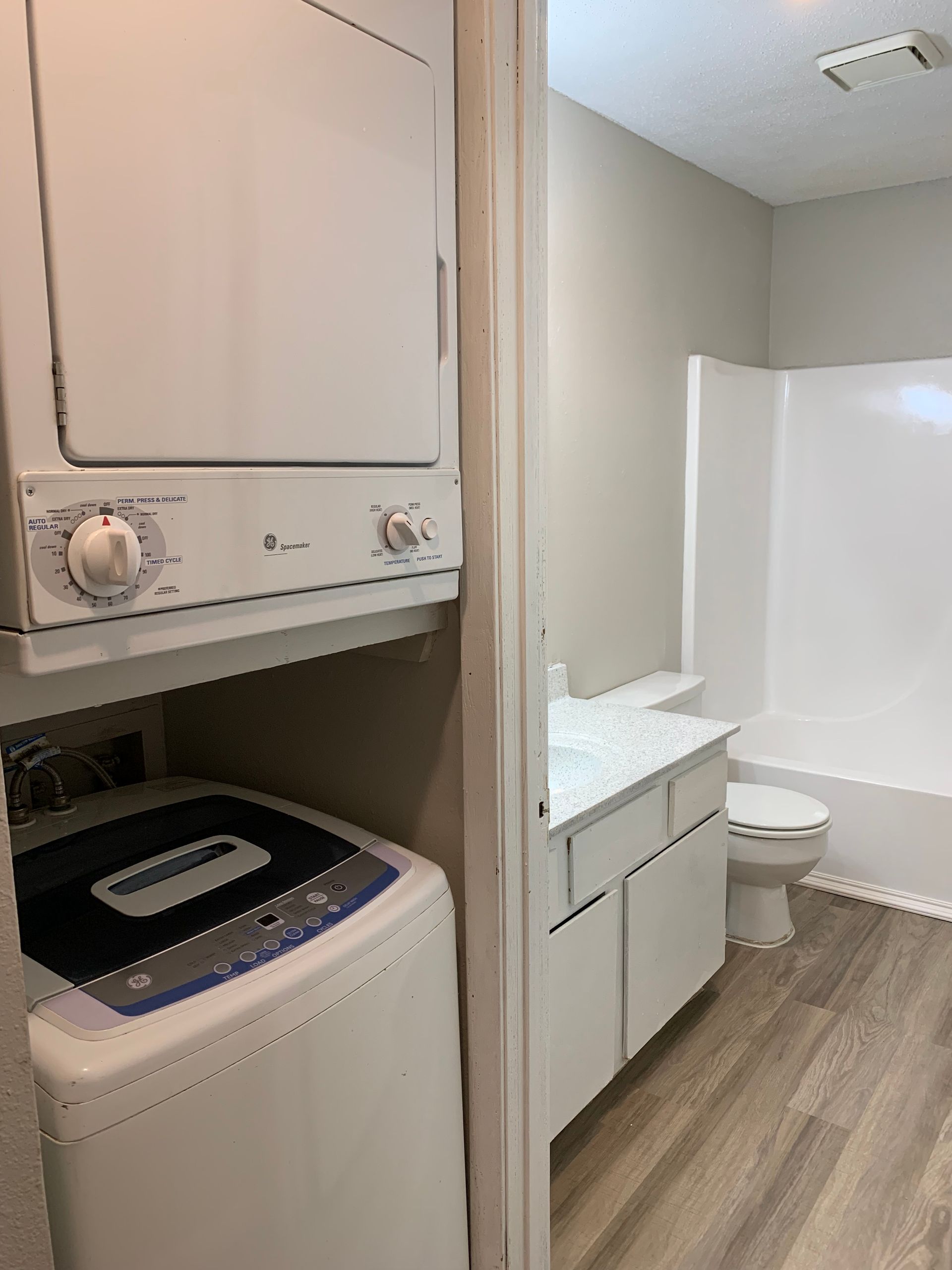 A washer and dryer are stacked on top of each other in a bathroom.