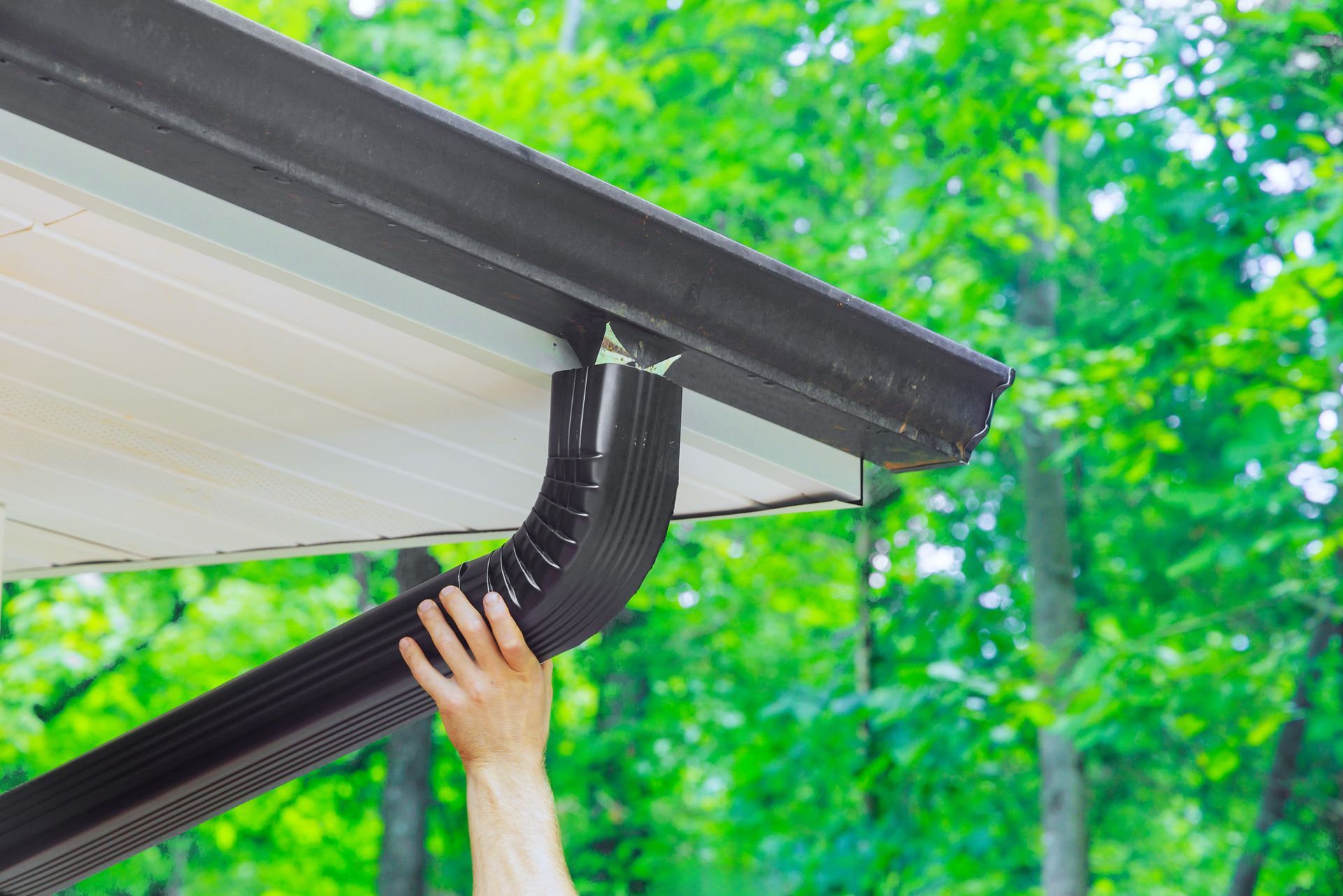 Close-up picture of an expert securing a gutter installation.