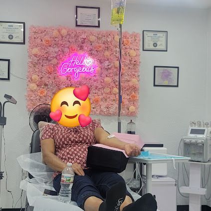 Person receiving IV treatment in a brightly decorated clinic, with a floral wall and 