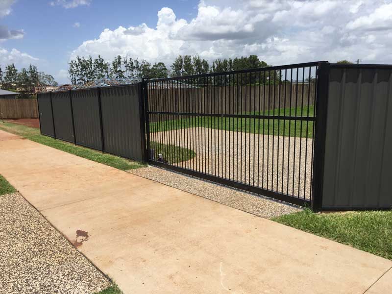 A Fence With a Sliding Gate is Next to a Sidewalk — Fencing Around In Mareeba, QLD