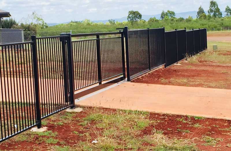 A Black Metal Fence With a Gate in the Middle of a Field — Fencing Around In Mareeba, QLD