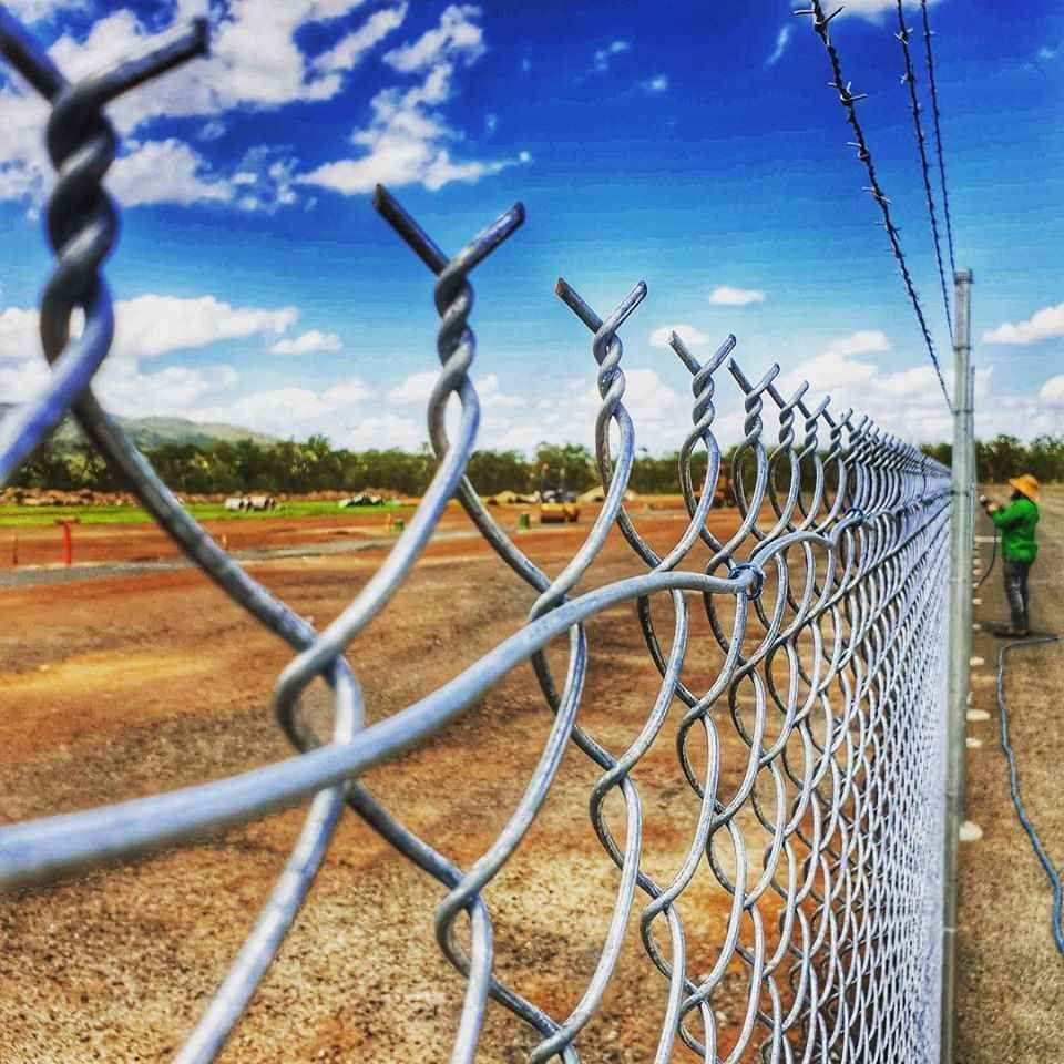 A Chain Link Fence is Surrounding a Dirt Field — Fencing Around In Mareeba, QLD