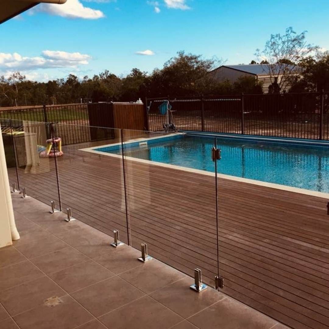 A Swimming Pool is Surrounded by a Glass Fence and a Wooden Deck — Fencing Around In Mareeba, QLD