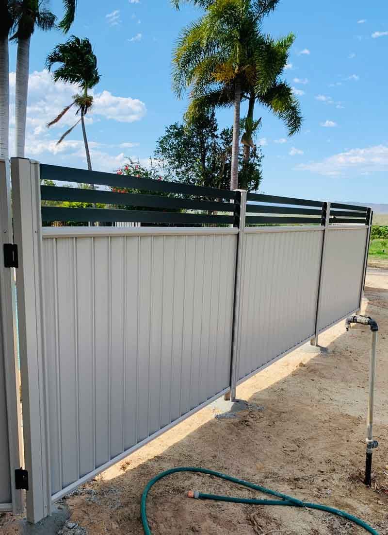 A White Fence With a Green Hose Next to It — Fencing Around In Mareeba, QLD