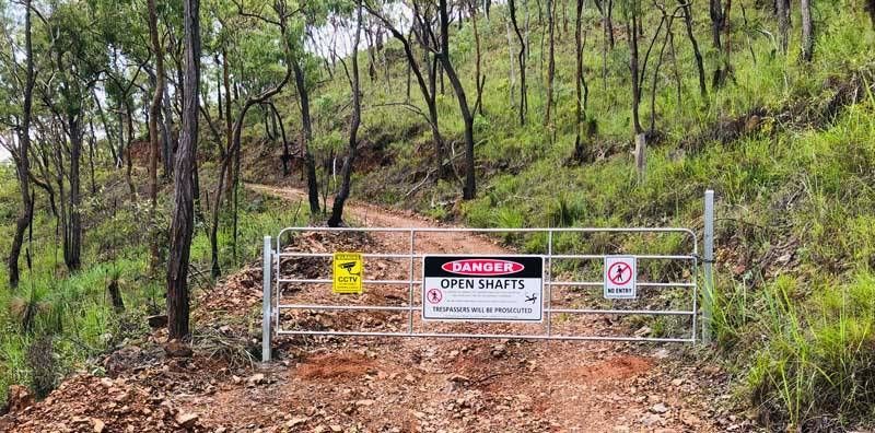 A Gate With a Danger Sign on It in the Middle of a Forest — Fencing Around In Mareeba, QLD