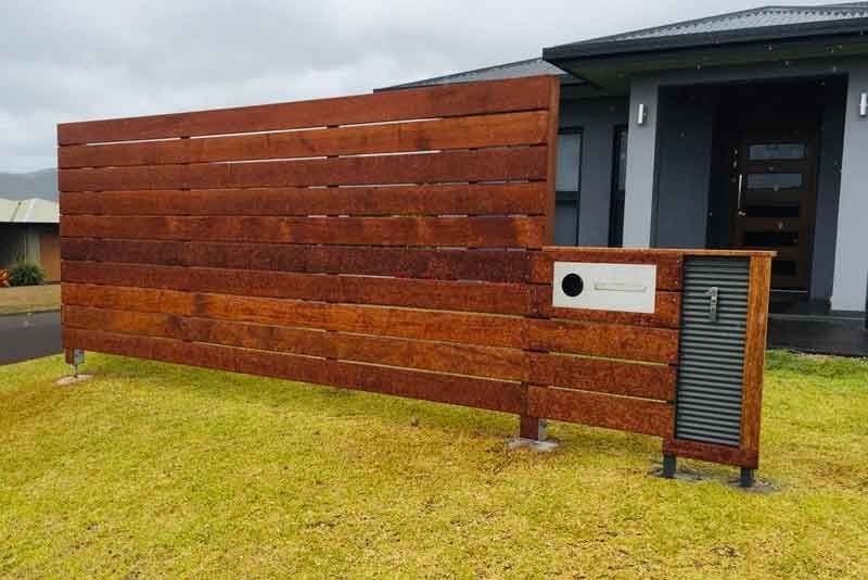 A Wooden Fence With a Mailbox in Front of a House — Fencing Around In Mareeba, QLD