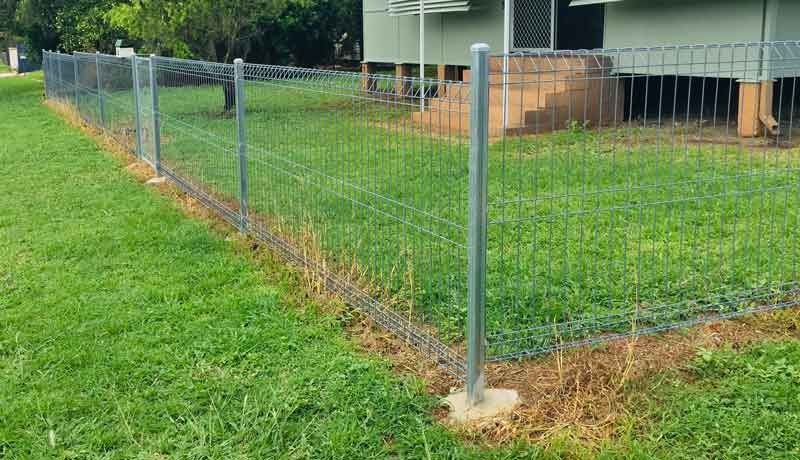 A Fence is Surrounding a Lush Green Lawn in Front of a House — Fencing Around In Mareeba, QLD