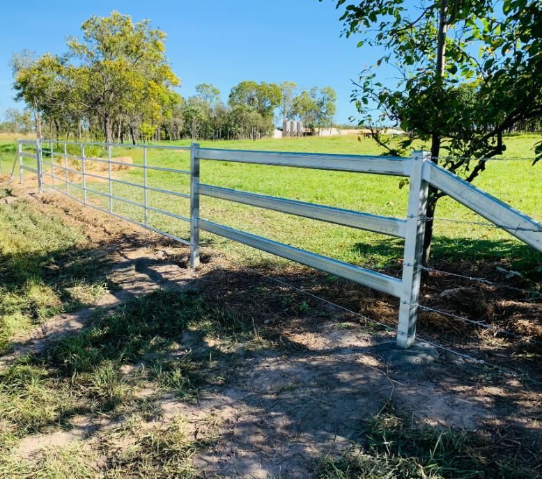 A White Fence Surrounds a Grassy Field With Trees in the Background — Fencing Around In Mareeba, QLD