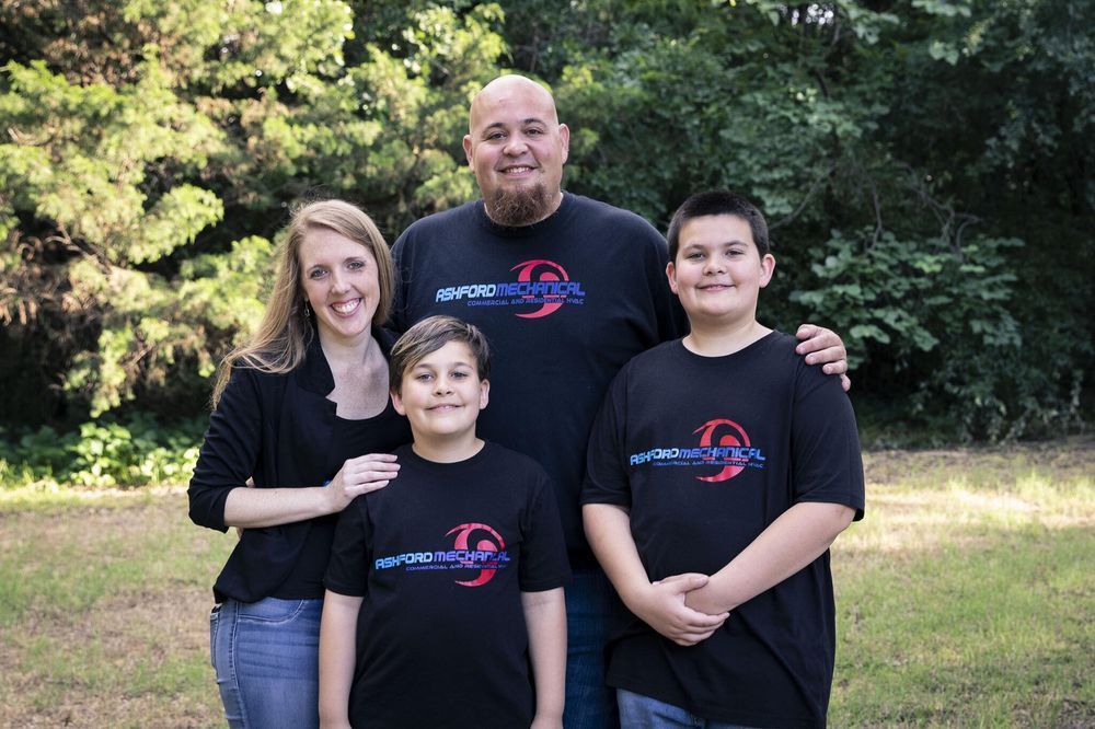 A family is posing for a picture in a field.