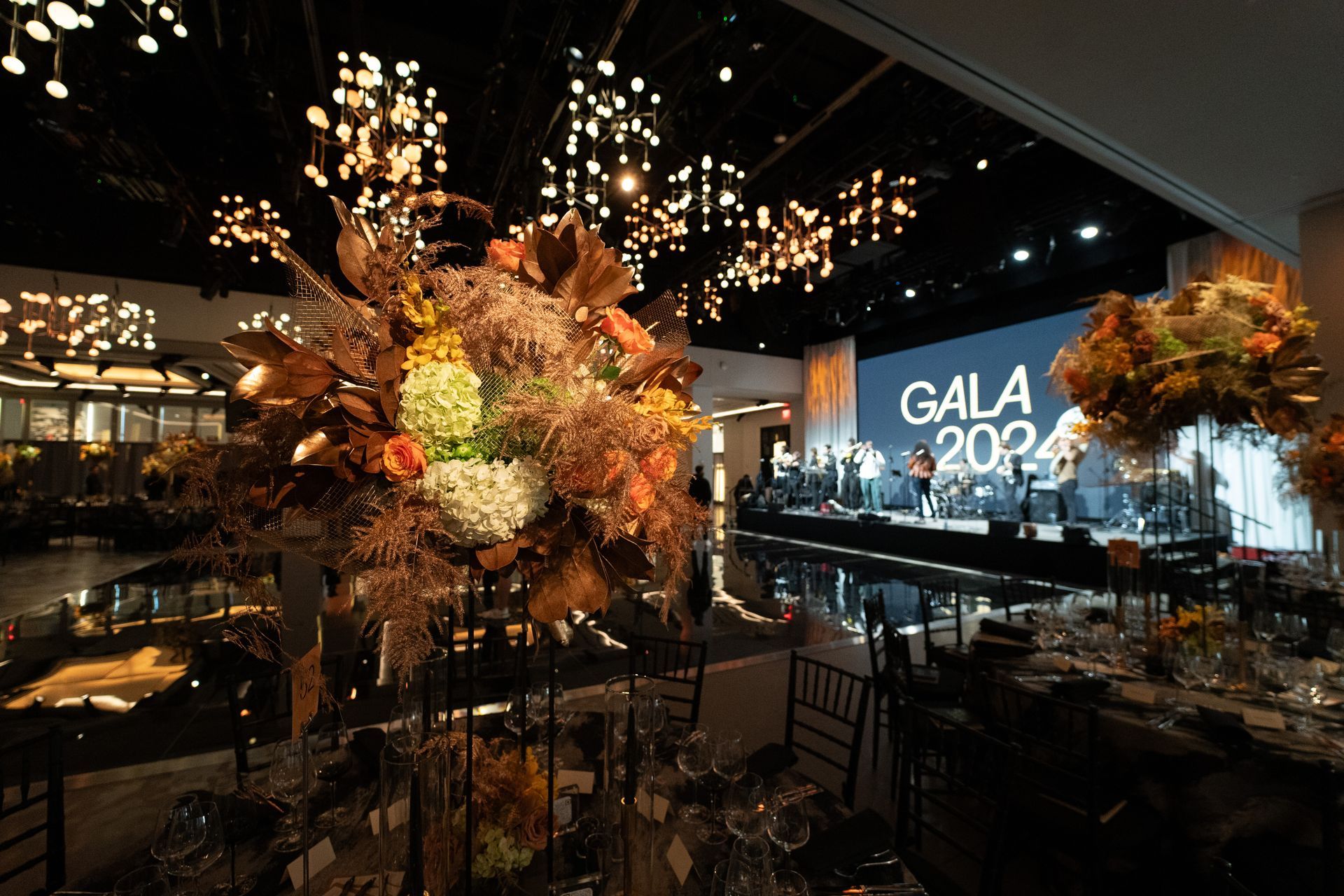 A large room with tables and chairs set up for a gala.