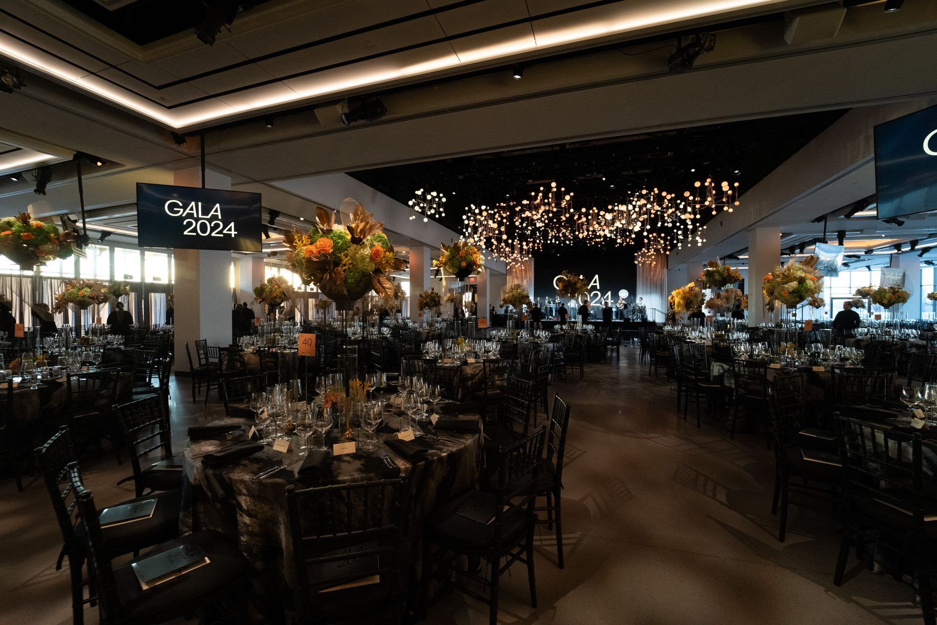 A large room with tables and chairs set up for a gala.