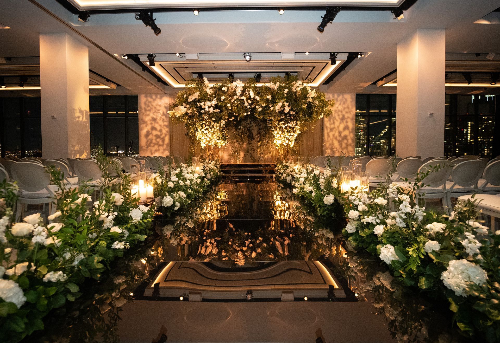 A large room with a circular dance floor and a chandelier hanging from the ceiling.