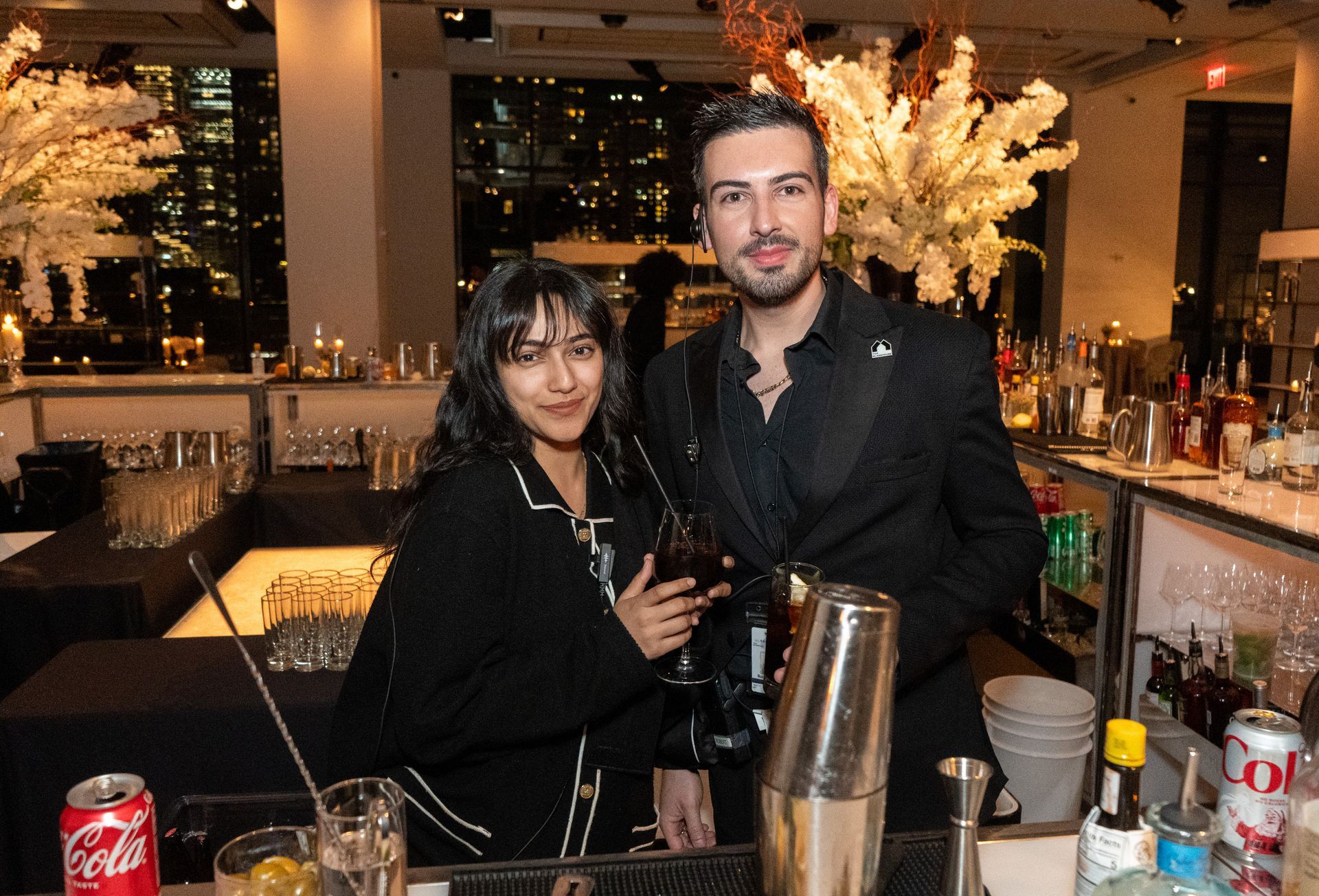 A man and a woman are standing next to each other in a bar.