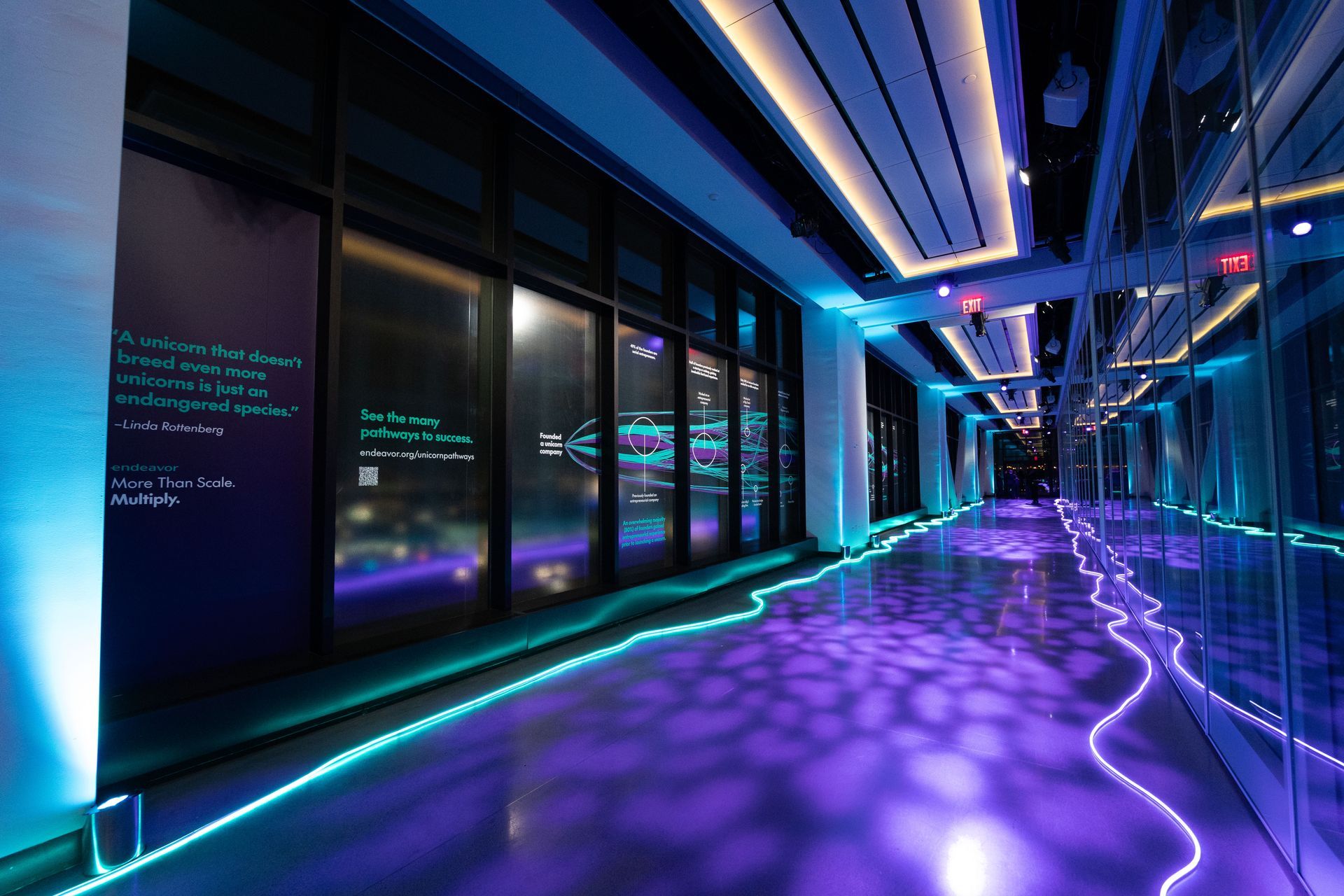 A long hallway with purple lights on the floor and walls