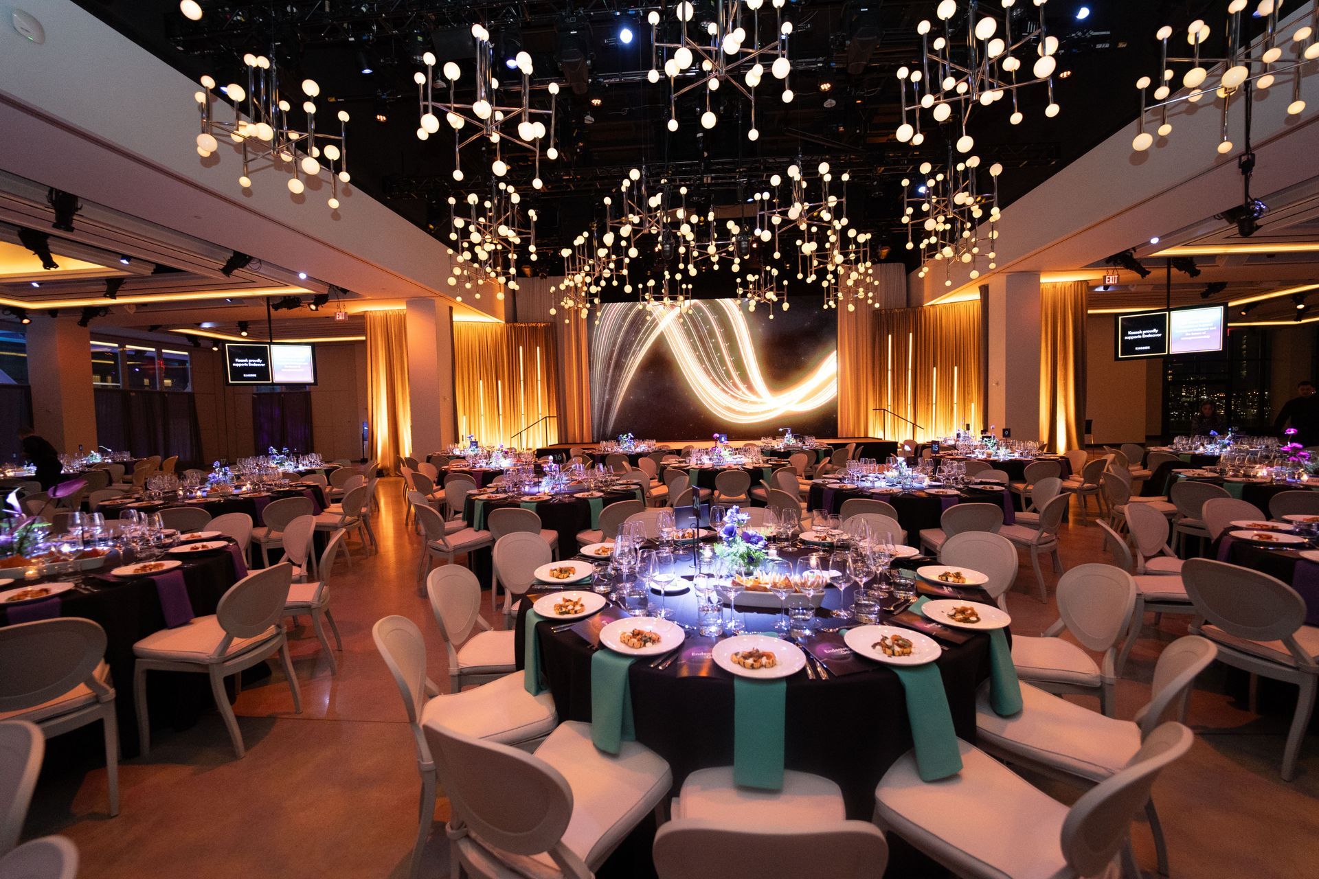 A large room with tables and chairs set up for a party.
