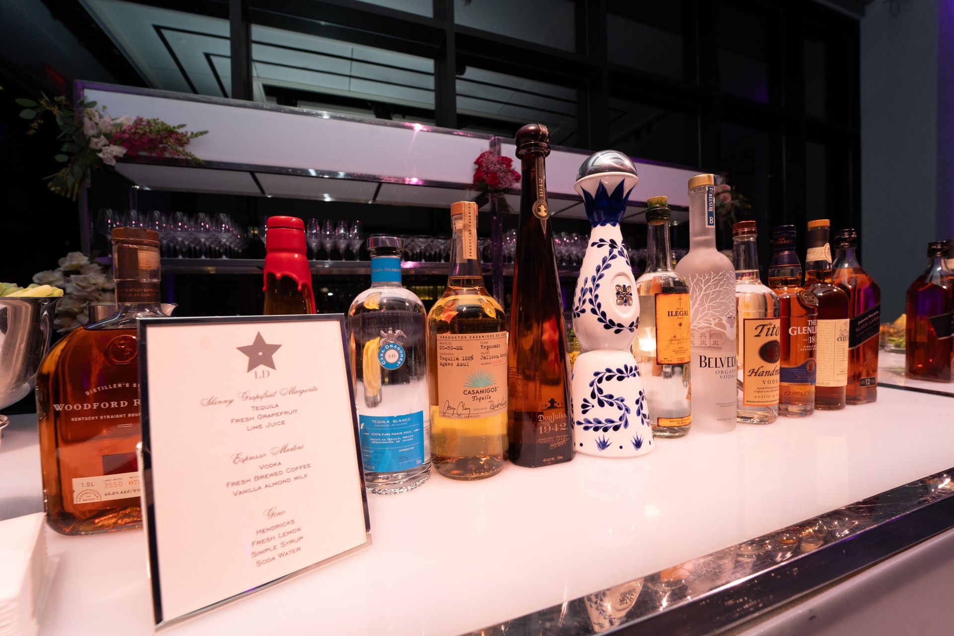 Bar with various tequila bottles displayed on a white counter. A menu is visible.
