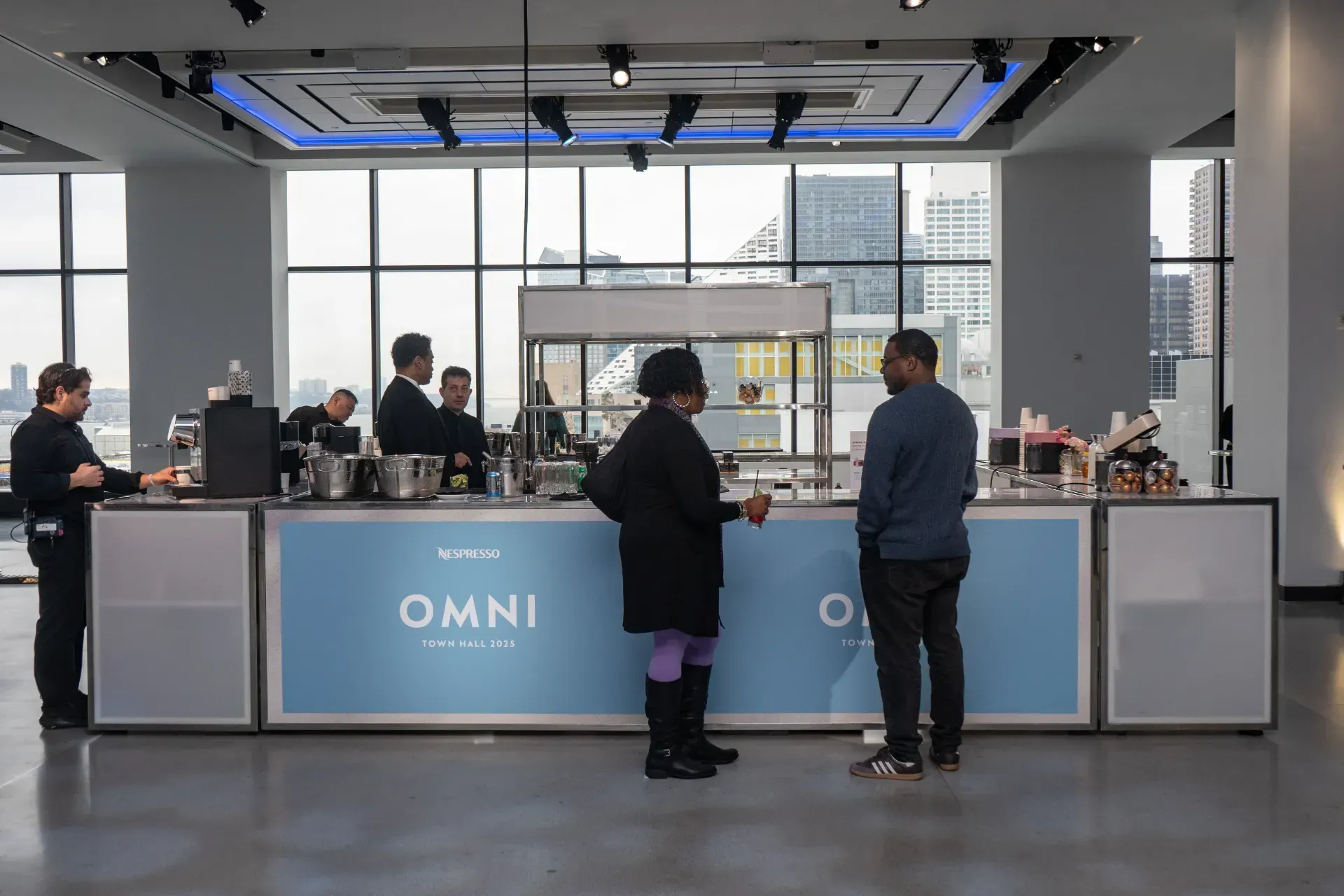 A group of people are standing around a counter in a restaurant.