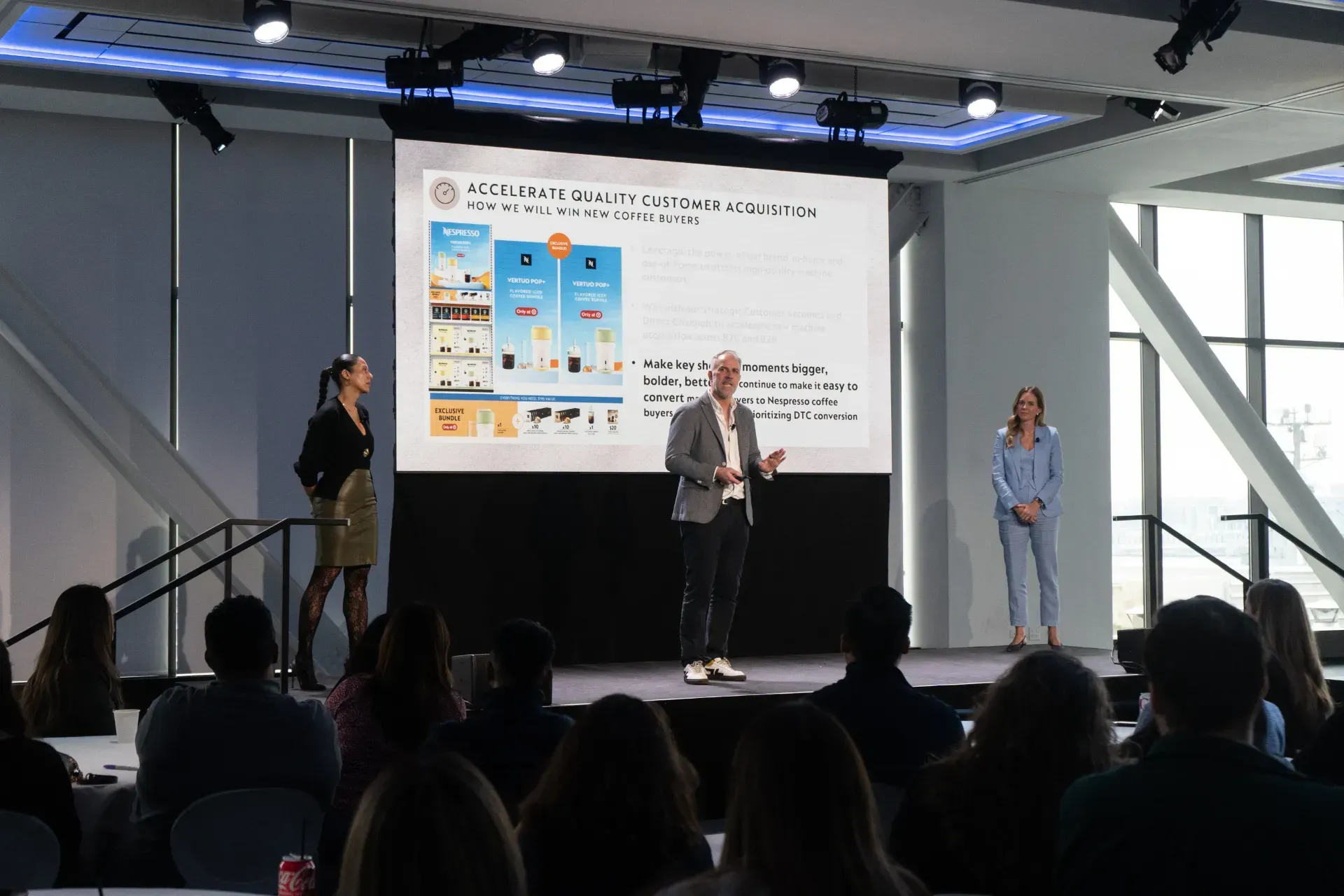 A man is giving a presentation to a group of people in front of a large screen.