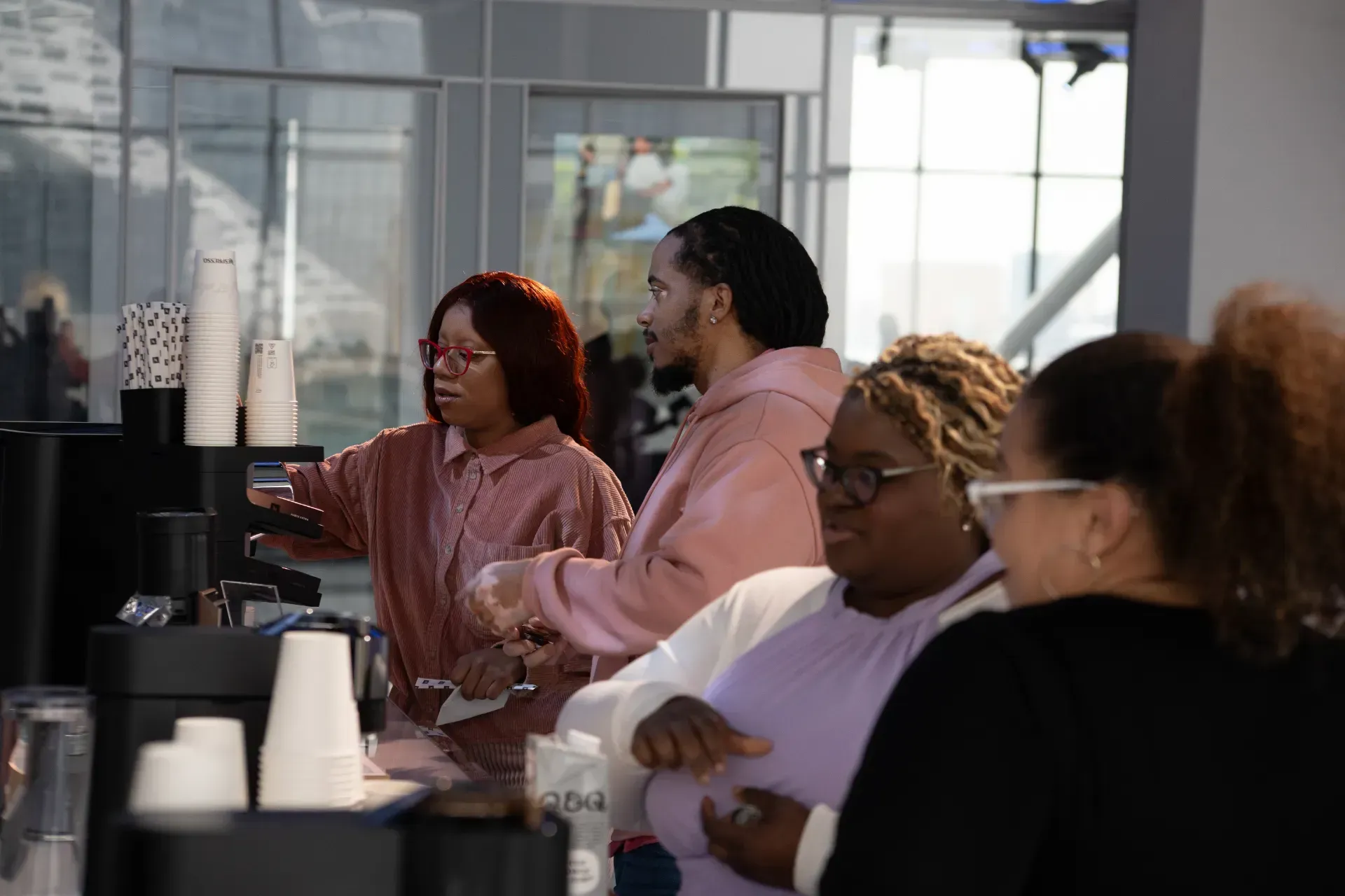 A group of people are standing around a counter in a restaurant.