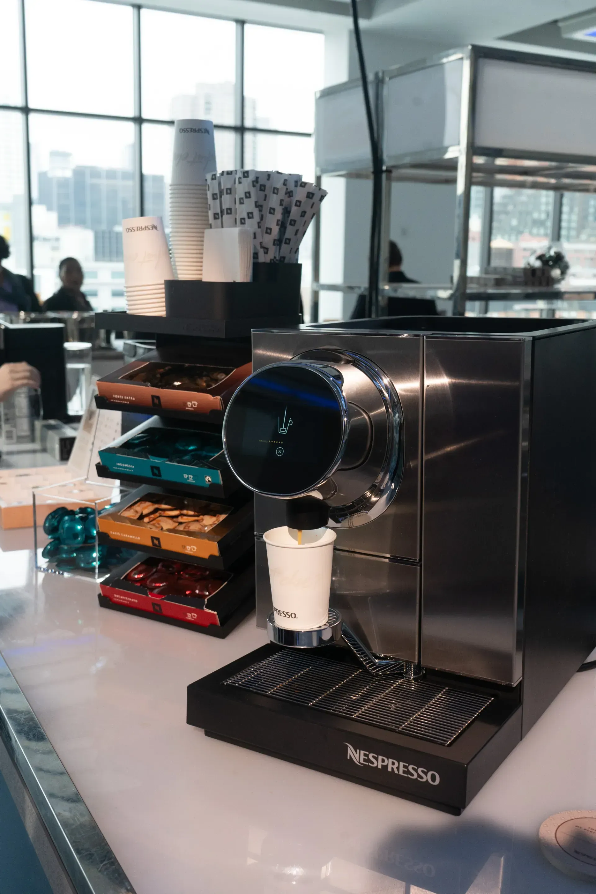 A nespresso coffee machine is sitting on a counter in a restaurant.