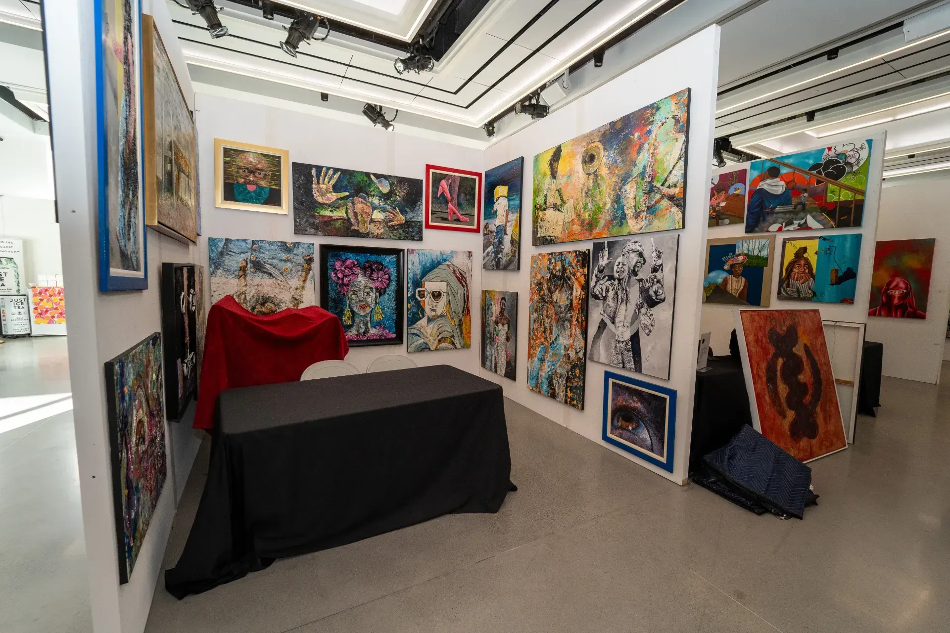 A room filled with lots of paintings on the walls and a table.