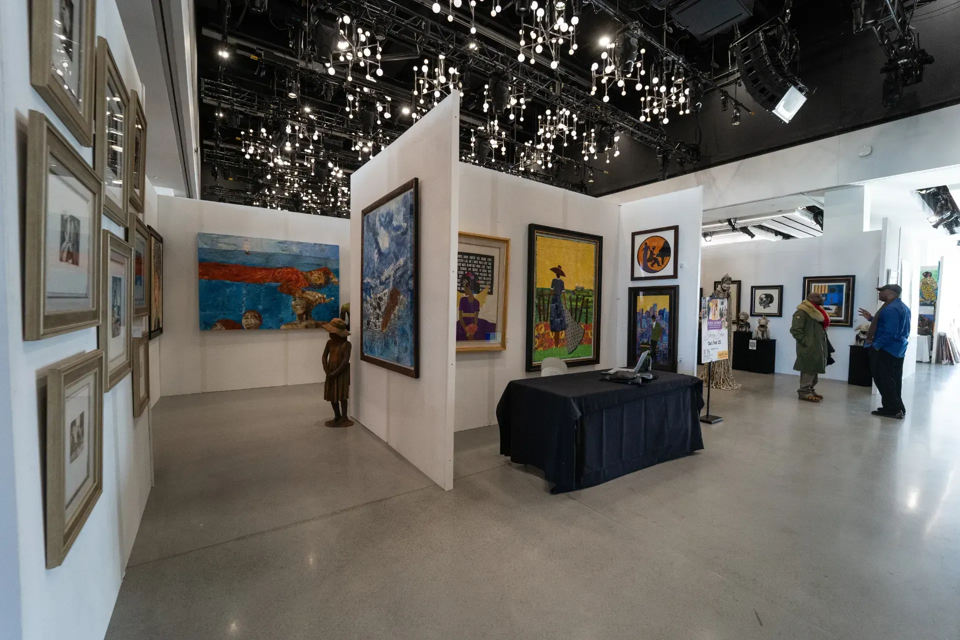 A group of people are looking at paintings in a museum.
