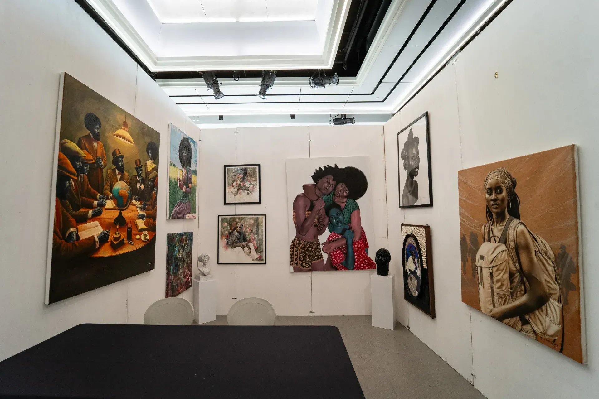 A room filled with paintings on the walls and a table.