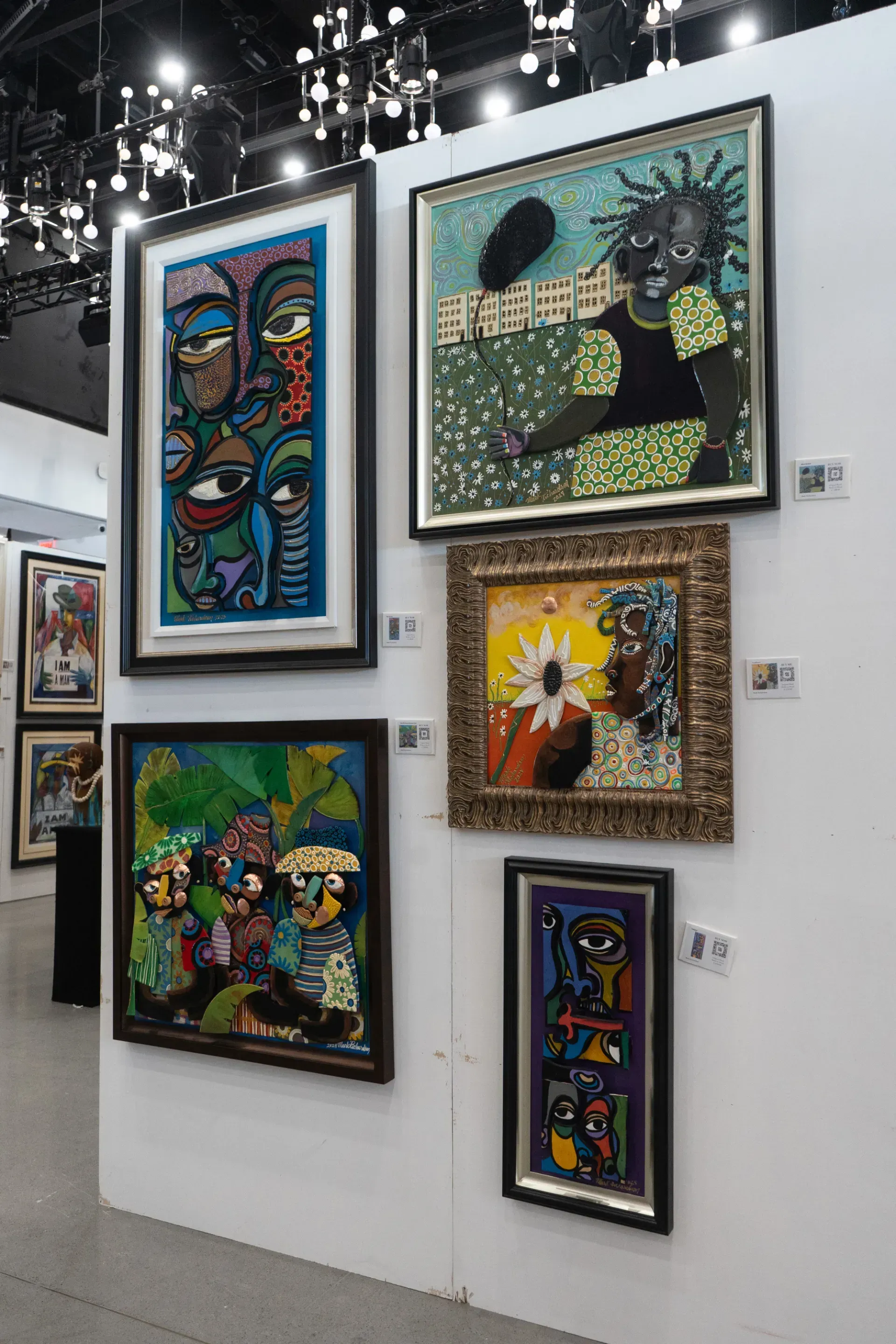 A wall with a bunch of framed paintings on it