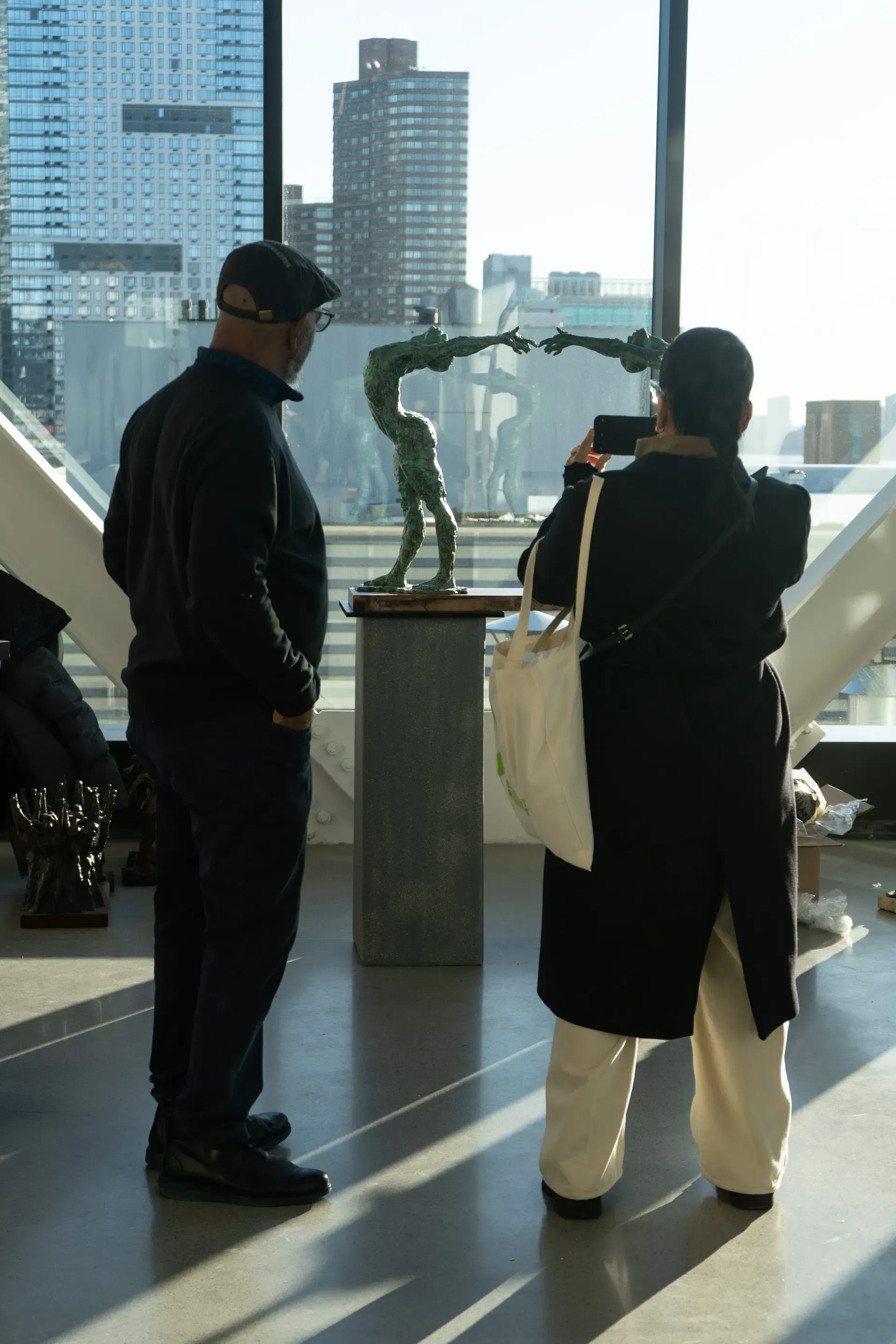 A man and a woman are looking at a statue in a museum.