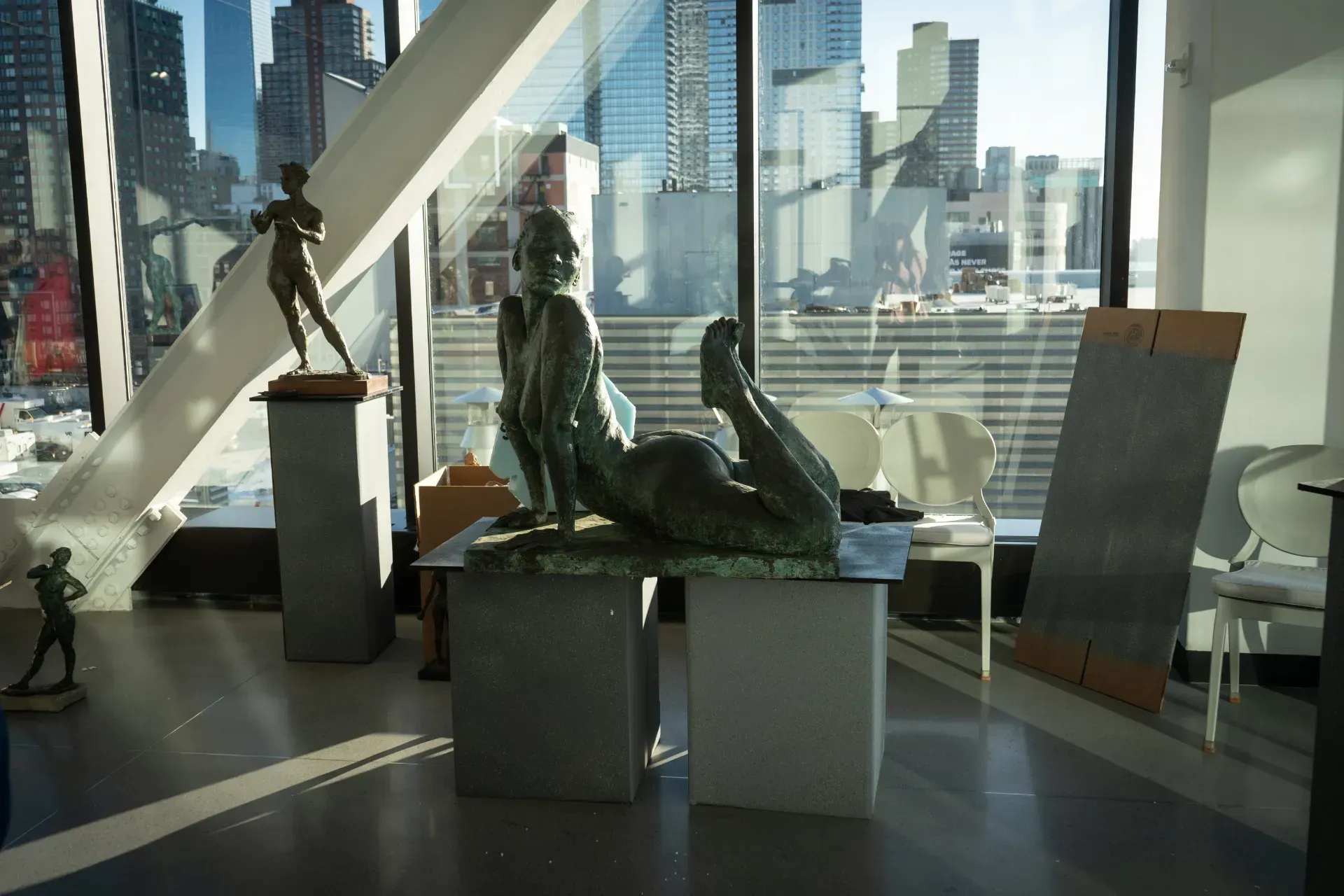 A statue of a woman laying on a table in front of a window