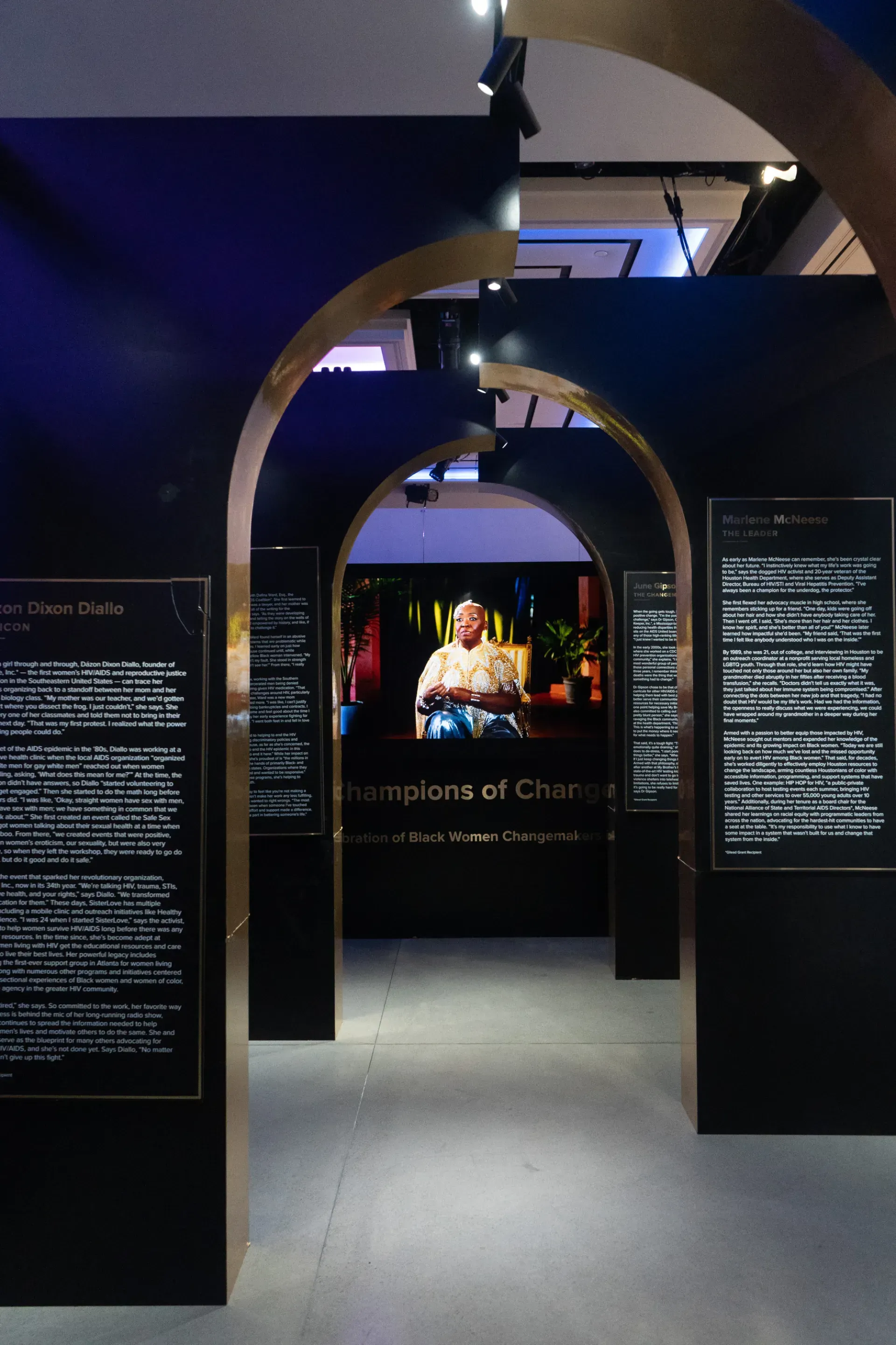 A man is sitting in a chair in front of a screen in a museum.